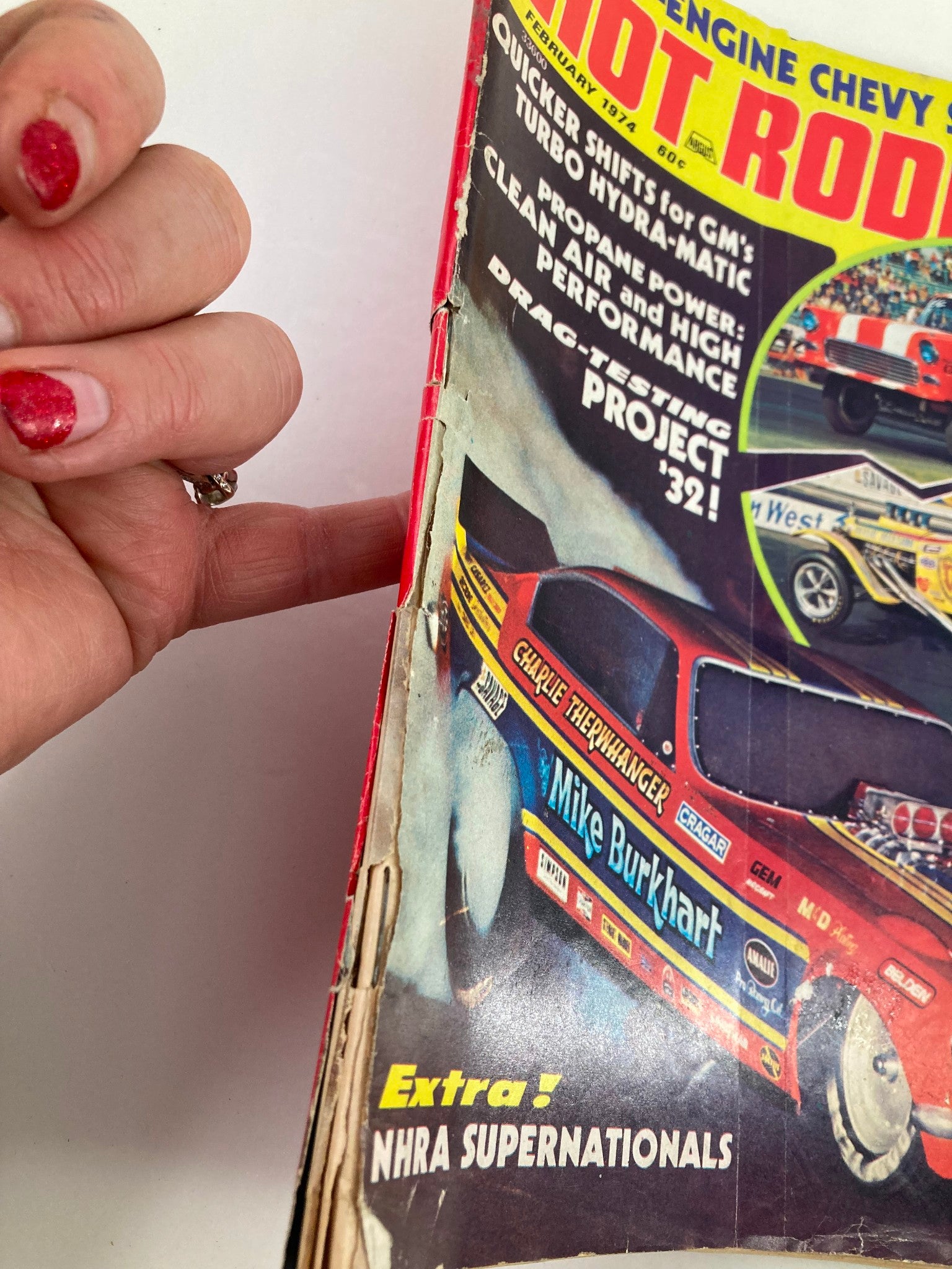 Side view of VTG Hot Rodding Magazine February 1974 Vol 13 #2 showcasing the damage on the cover, emphasizing the vintage character of the magazine.