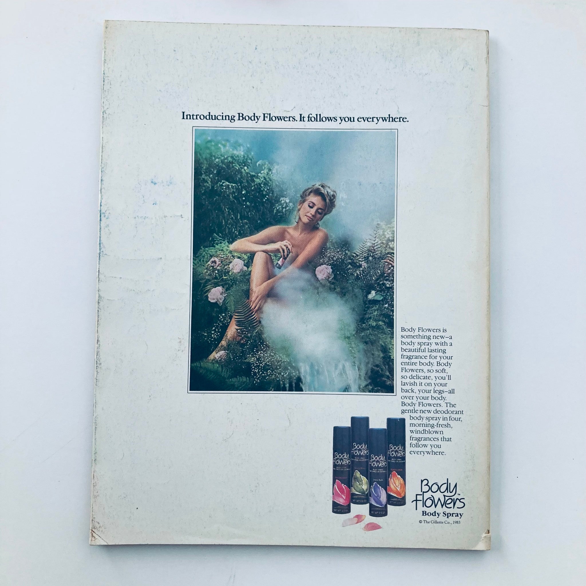 Back cover of VTG Seventeen Magazine November 1984 featuring an advertisement for Body Flowers body spray. The image showcases a model surrounded by lush greenery, highlighting the product's appeal. This collectible magazine issue includes stunning visuals and nostalgic content, making it a valuable find for vintage magazine enthusiasts.