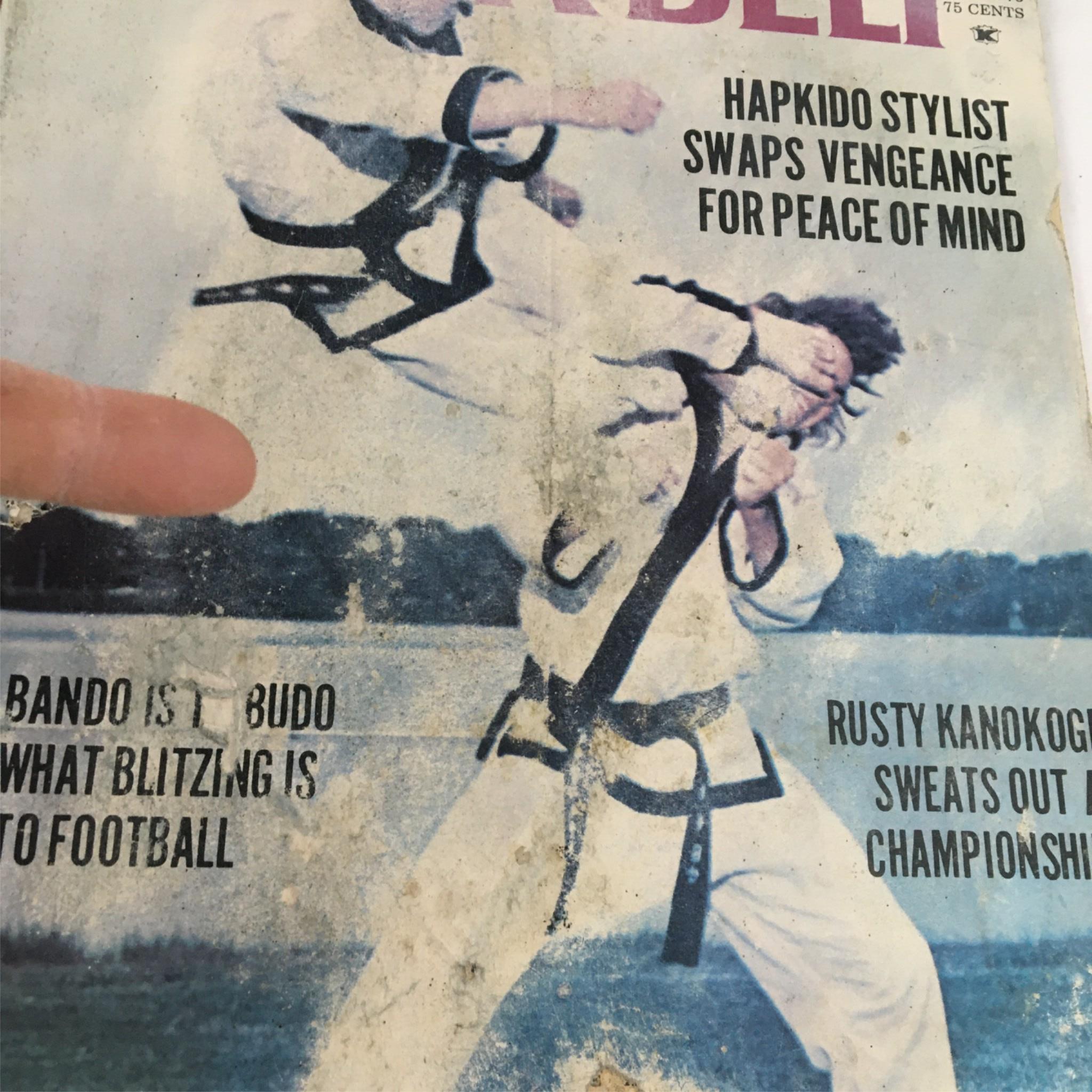 Close-up of the cover of Black Belt Magazine January 1975, showcasing martial arts practitioners and the text 'Hapkido Stylist Swaps Vengeance for Peace of Mind'. This vintage magazine cover emphasizes Rusty Kanokogi's influence in martial arts.