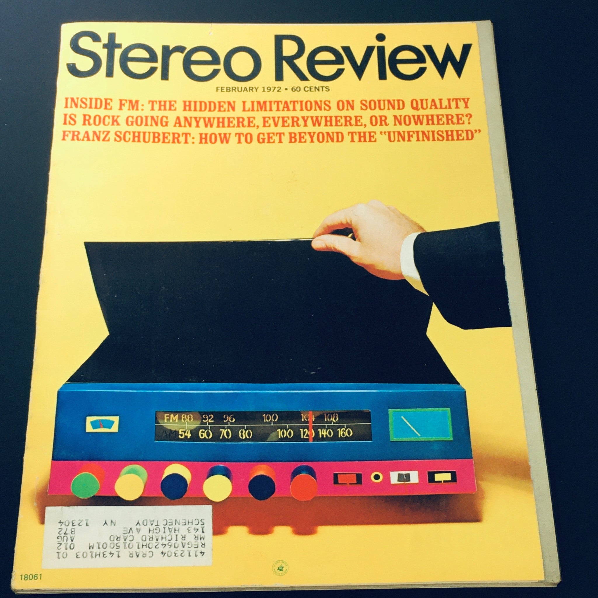 Cover of the Stereo Review Magazine, February 1972 - Featuring Franz Schubert's 'Unfinished' Symphony, showcasing a colorful stereo system with a hand reaching toward a music player, highlighting the era's sound technology and music culture.