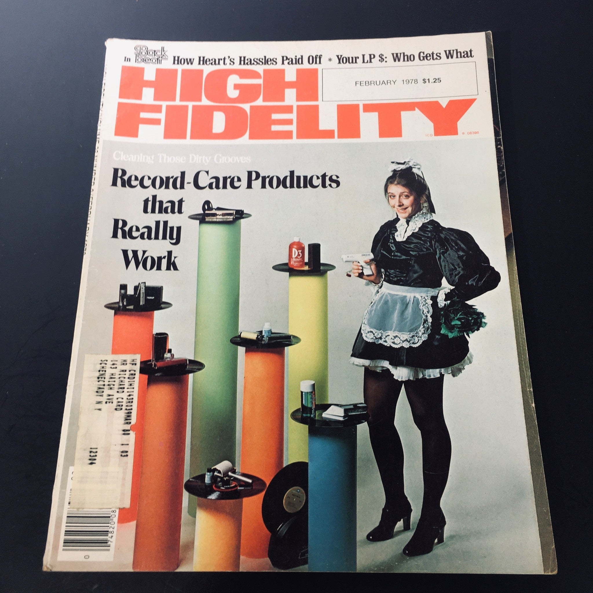 Cover of VTG High Fidelity Magazine February 1978 featuring record-care products, showcasing a woman in vintage attire posing with cleaning products next to colorful display stands.