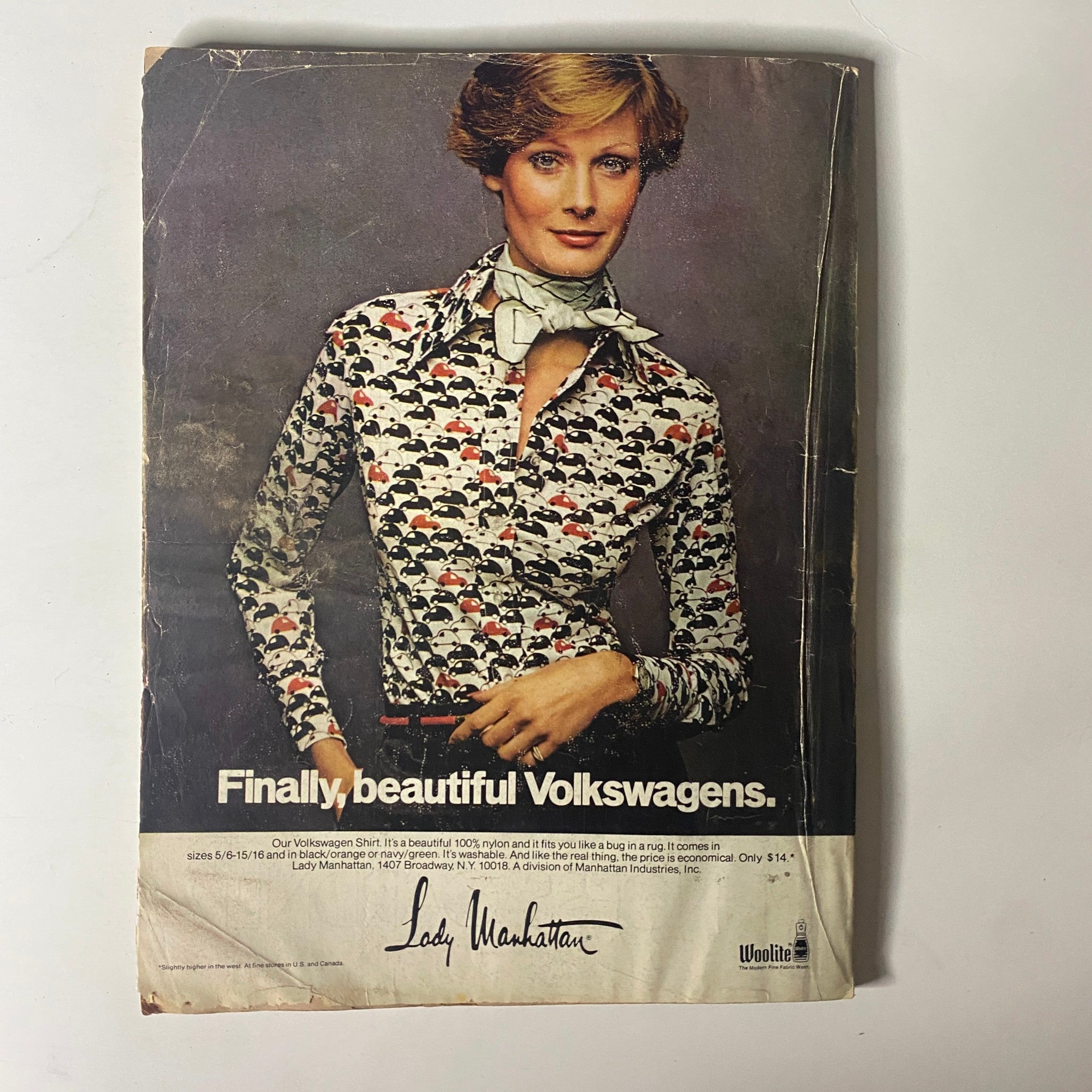 A vintage advertisement from Mademoiselle Magazine March 1974 featuring a model wearing a stylish shirt, promoting Volkswagen vehicles with a playful message.