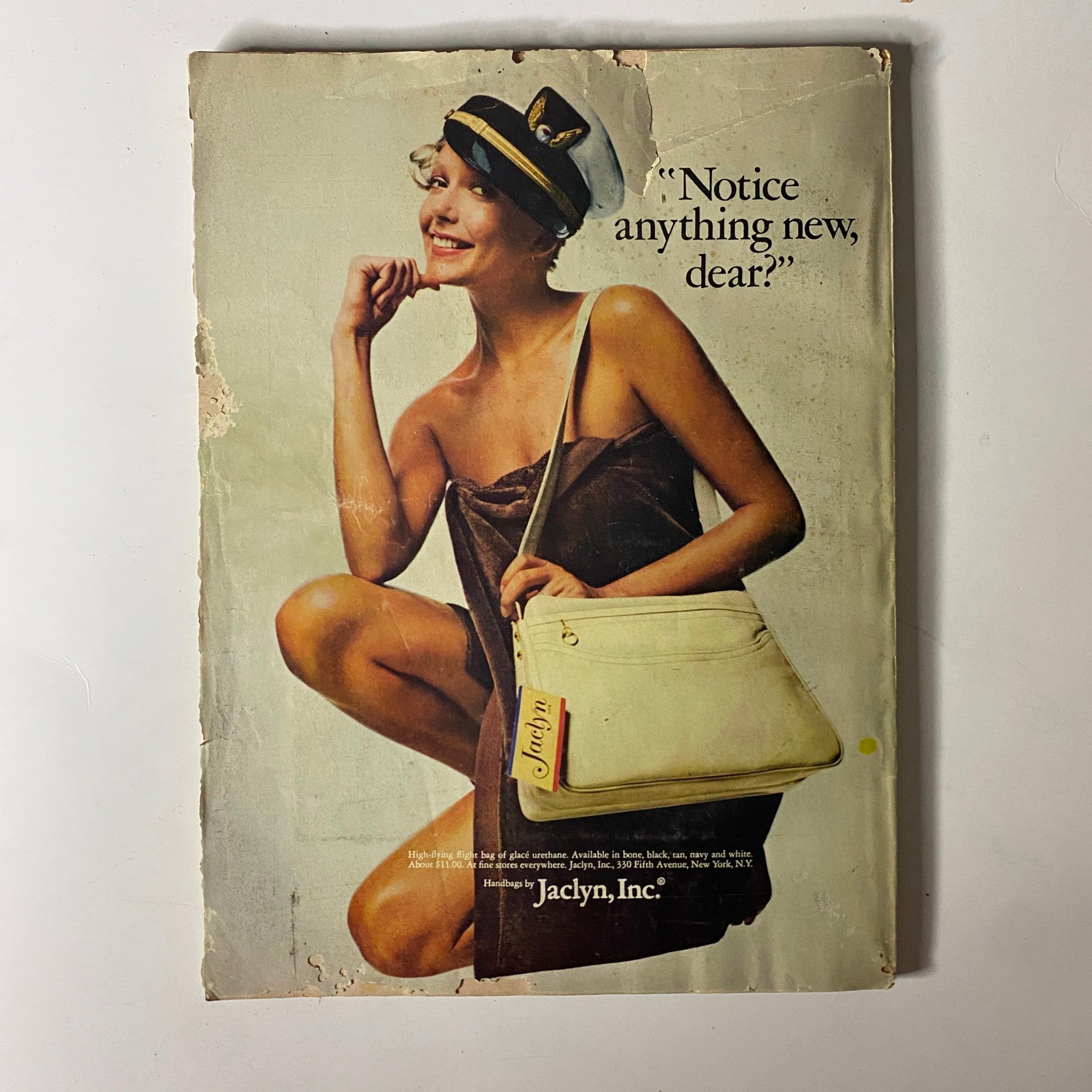 Back cover of Mademoiselle Magazine December 1972 showing a playful model in a dress, featuring the text 'Notice anything new, dear?' and promoting Jaclyn, Inc. fashion.