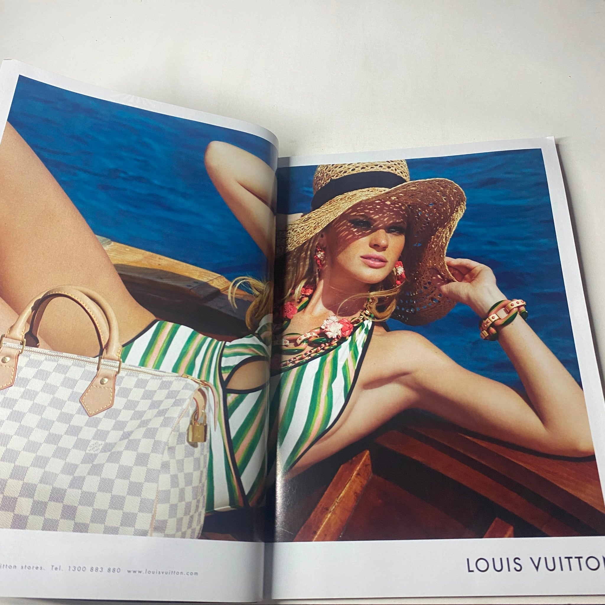 Fashion advertisement spread from Harper's Bazaar Australia December 2010, showcasing a model in swimwear with Louis Vuitton accessories.