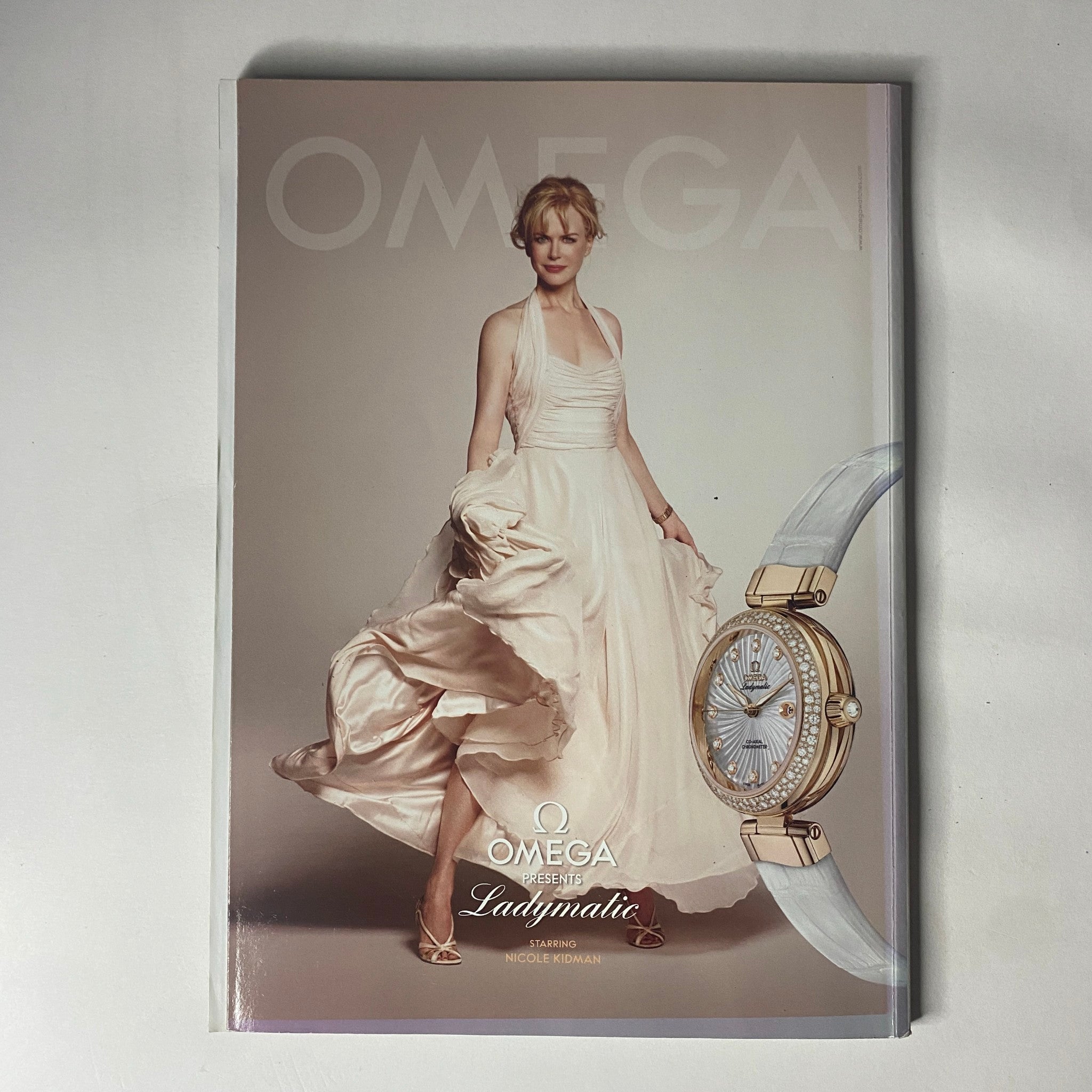 Harper's Bazaar Australia Magazine December 2010 cover featuring Nicole Kidman in an elegant gown promoting Omega's Ladymatic watch collection, emphasizing luxury and fashion.