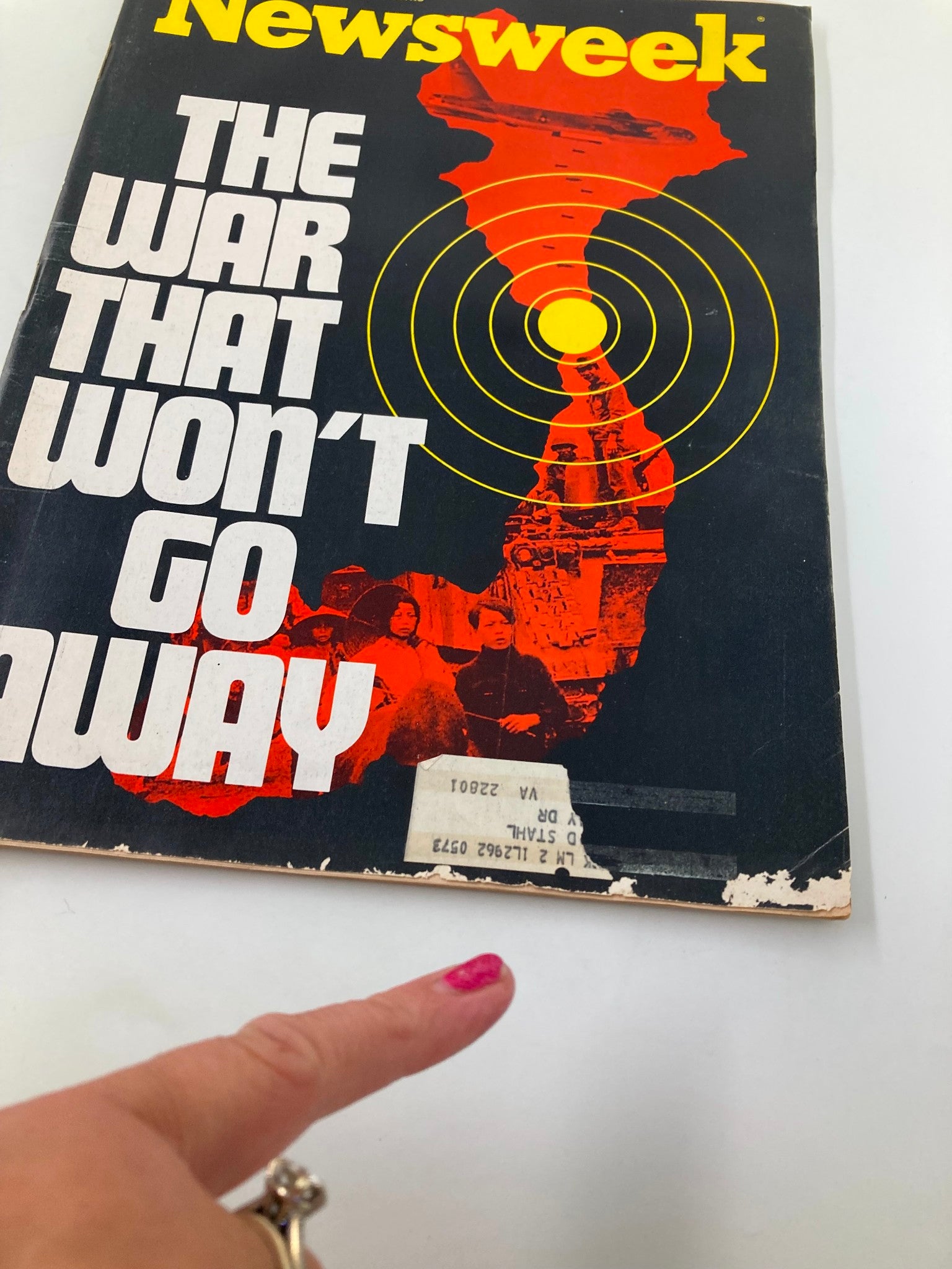 Close-up of the VTG Newsweek Magazine cover from April 17, 1972, showcasing the title 'The War That Won't Go Away' and details of its vintage condition with a finger pointing at the cover.
