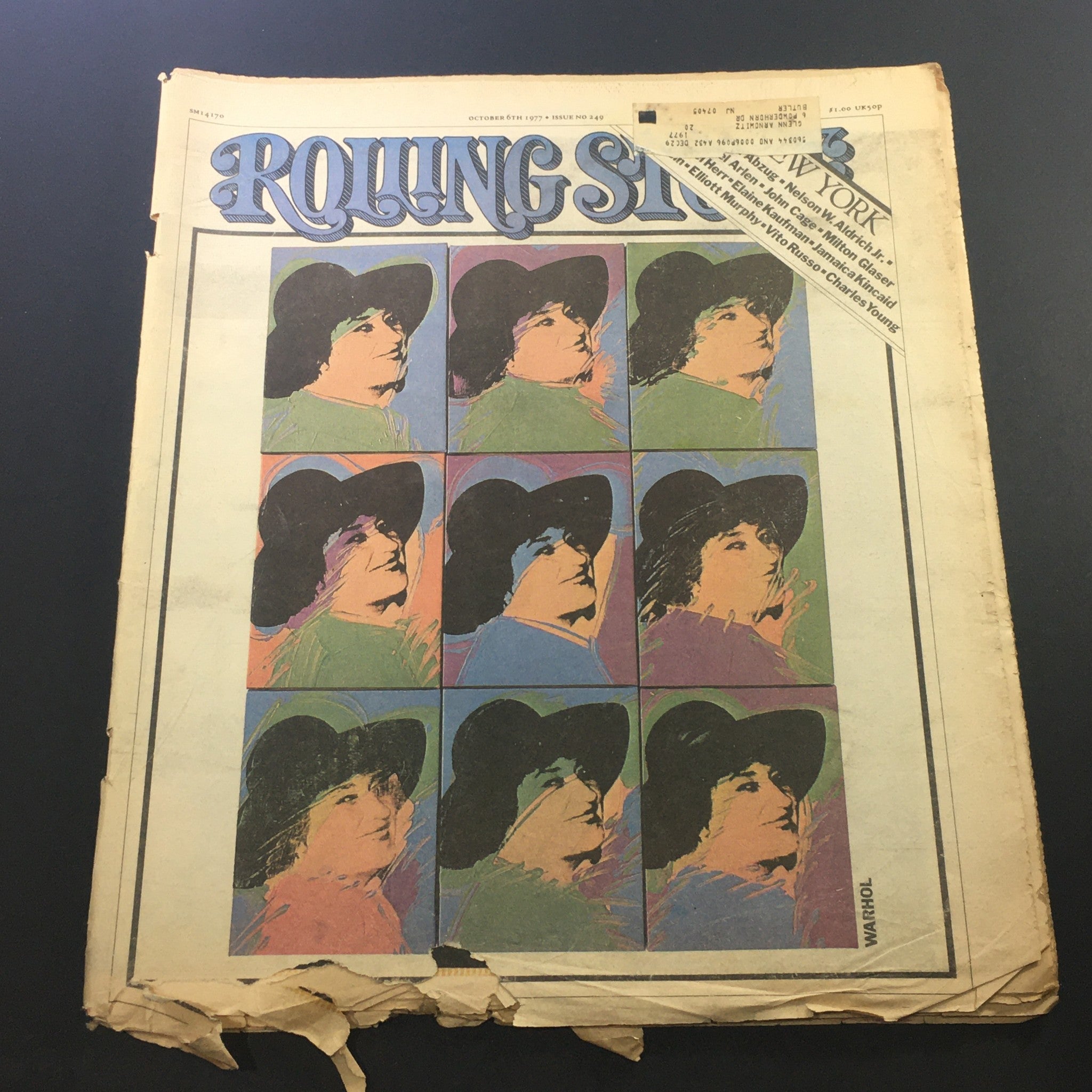 Vintage Rolling Stone Magazine Cover from October 6, 1977 featuring striking artwork and the title prominently displayed. This edition includes notable personalities like Nelson W. Aldrich Jr. and John Cage, offering a glimpse into the cultural and musical landscape of the late 1970s.