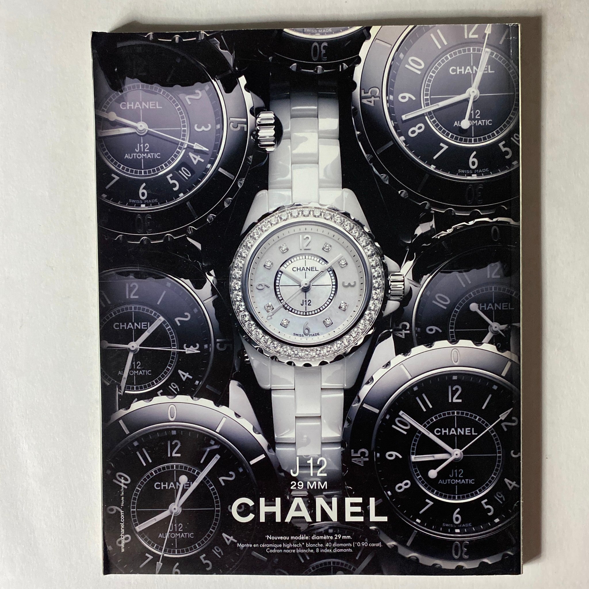 Chanel J12 29mm watch advertisement featuring a round, diamond-encrusted watch surrounded by various Chanel J12 timepieces, showcasing luxury and sophistication.