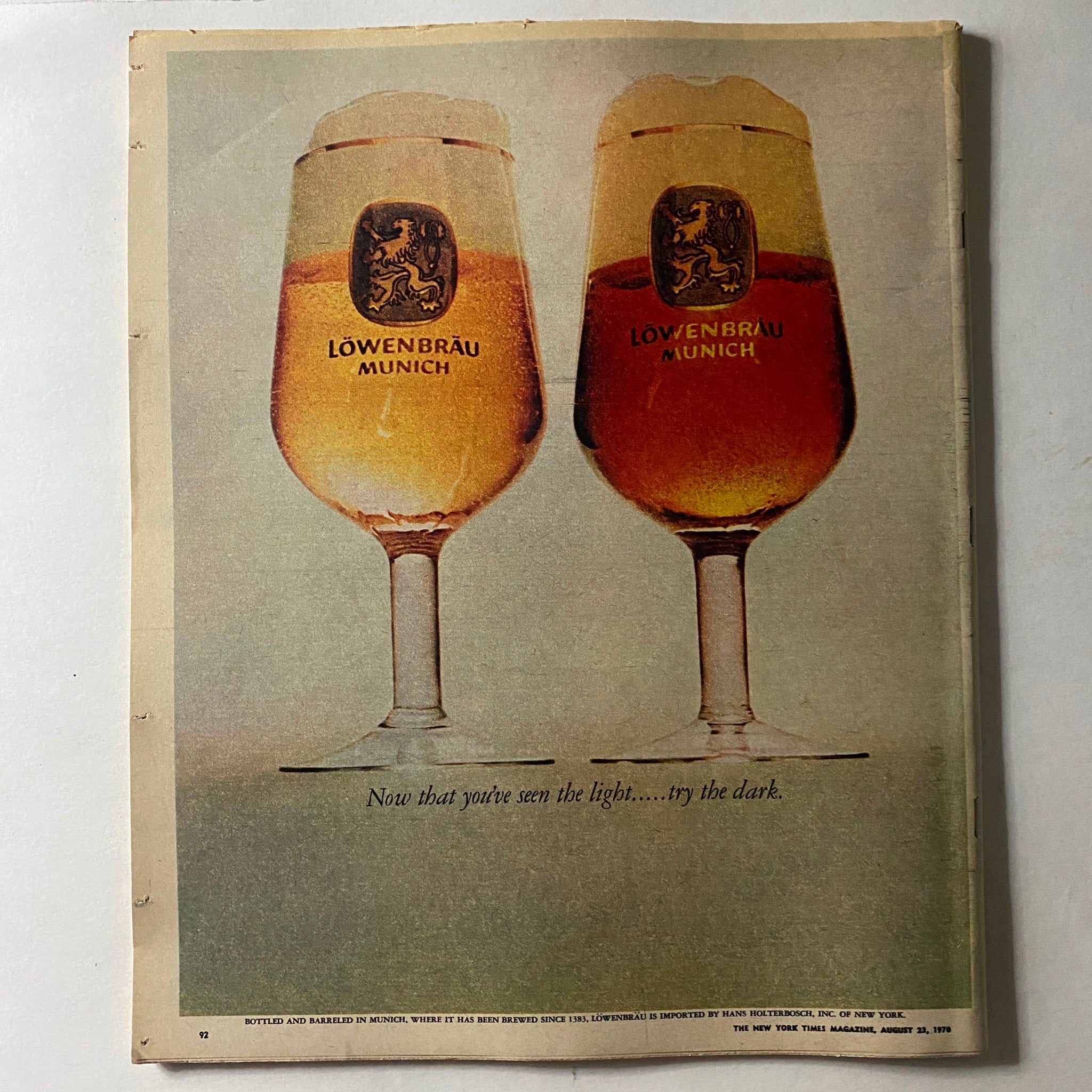 Vintage advertisement in The New York Times Magazine from August 23, 1970 featuring two Löwenbräu Munich beer glasses with the quote 'Now that you've seen the light... try the dark.'