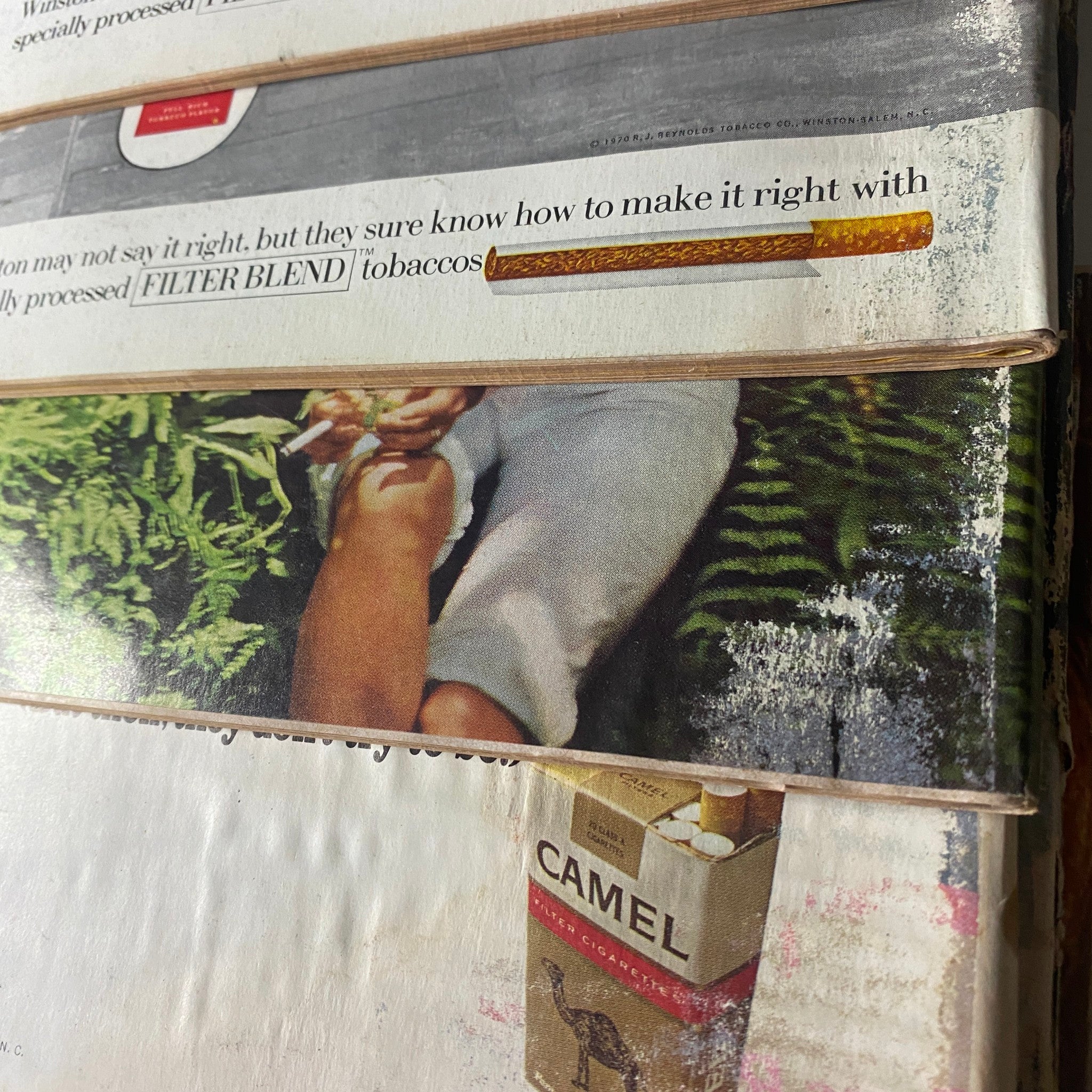 Close-up view of the spines of vintage Road & Track magazines from 1970, showcasing the title 'Lot of 12 Road & Track Magazines 1970 Car Auto Racing Full Year January-December' with visible advertisements and cover designs.