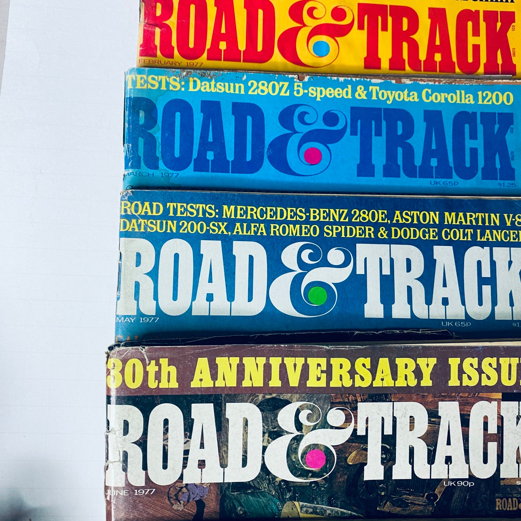Lot of 10 Road & Track Magazine 1977 February, March, May, June, August-December showcasing colorful magazine covers highlighting car tests, automotive features, and the 30th anniversary issue.