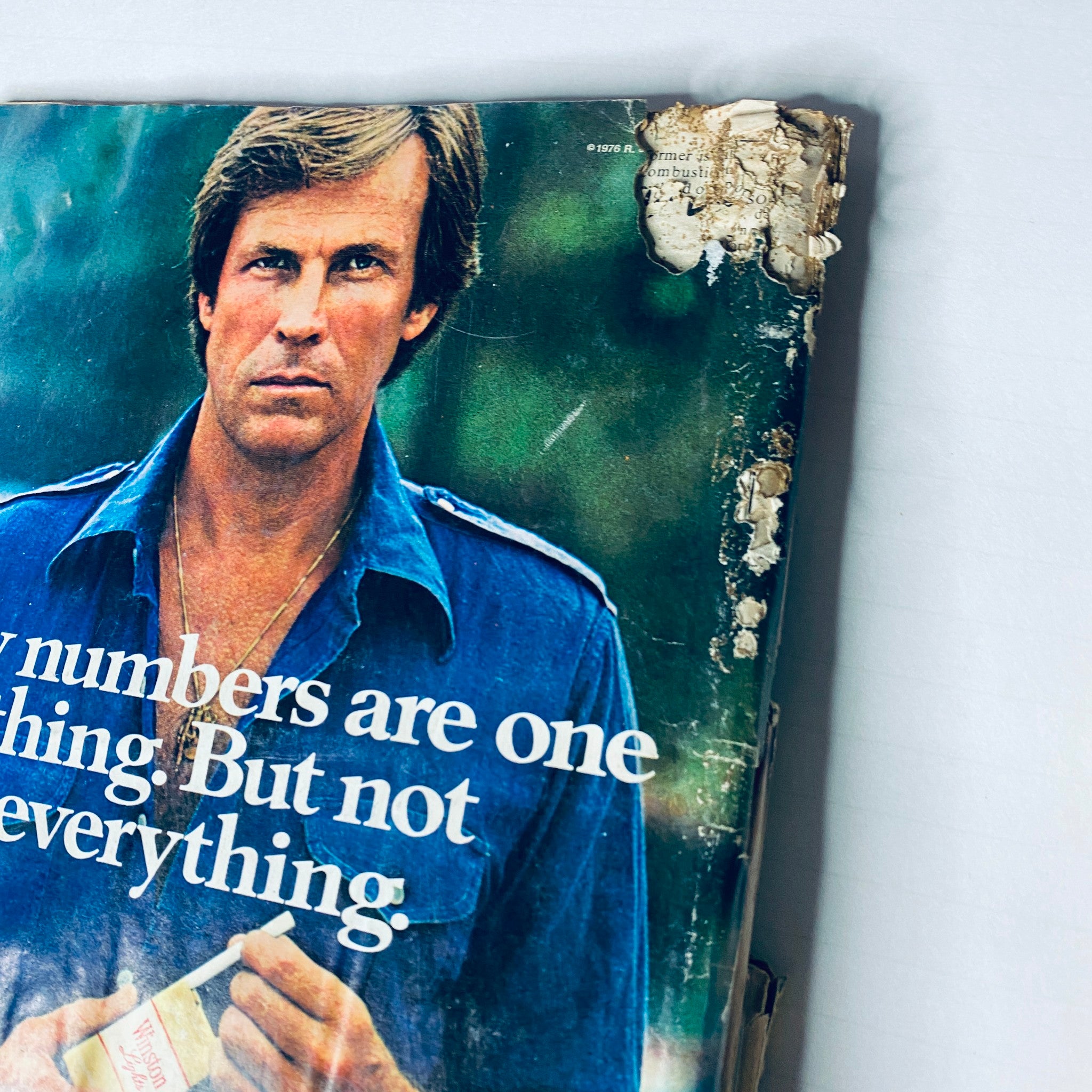 Cover of Road & Track Magazine from February 1977 featuring a man in a blue shirt and a damaged top corner. Title: Lot of 10 Road & Track Magazine 1977 February, March, May, June, August-December.