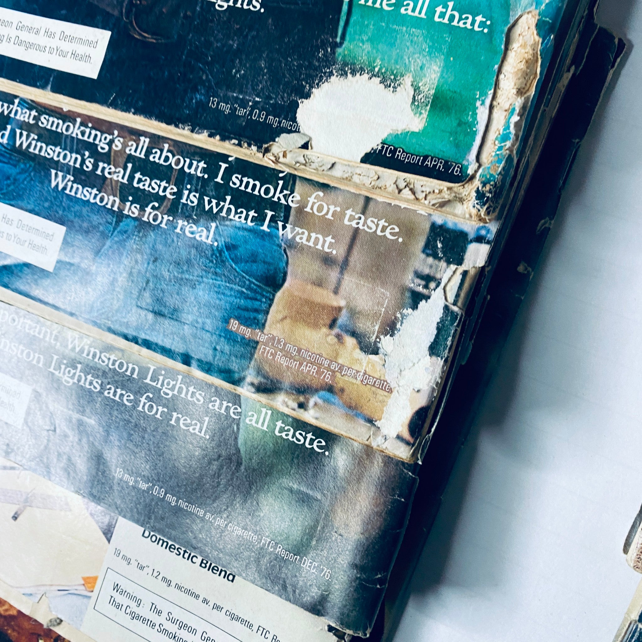 Close-up of a stack of Road & Track Magazine pages showing advertisements related to Winston cigarettes, with visible wear and tear. Title: Lot of 10 Road & Track Magazine 1977 February, March, May, June, August-December.