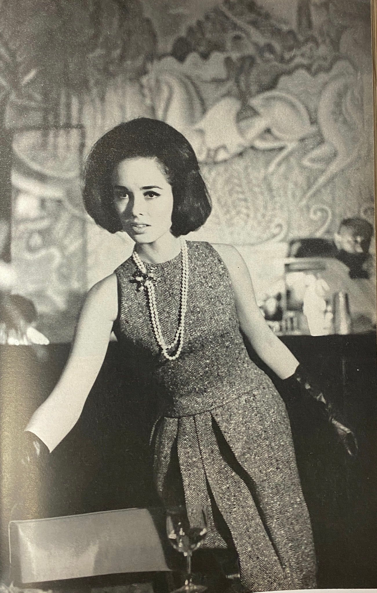 A vintage black and white fashion photograph from Glamour Magazine September 1962, featuring a model wearing elegant attire with pearls and gloves.