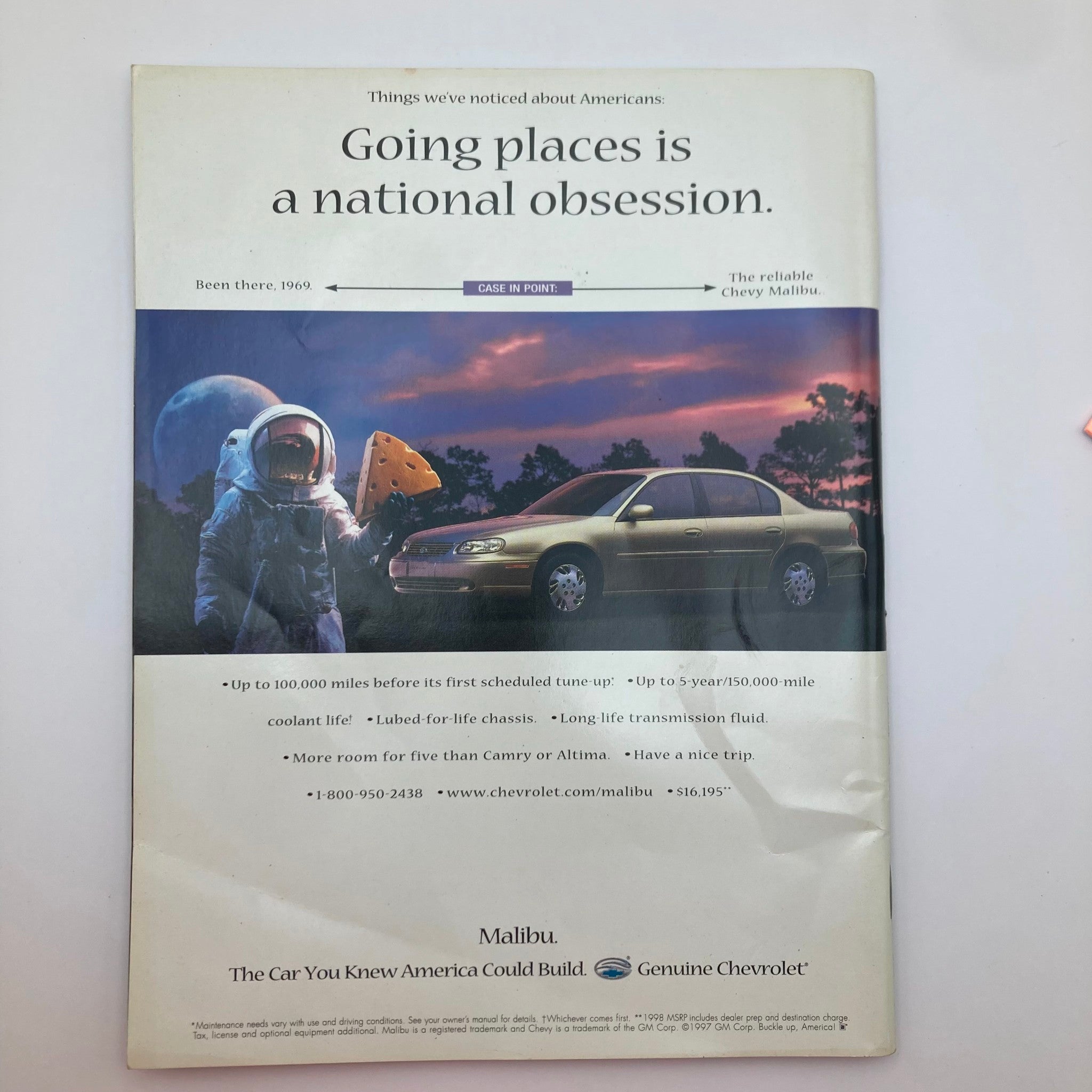 Vintage advertisement from the People Weekly Magazine Fall 1997 featuring a humorous concept of an astronaut holding cheese and a Chevy Malibu car, highlighting the theme 'Going places is a national obsession'.