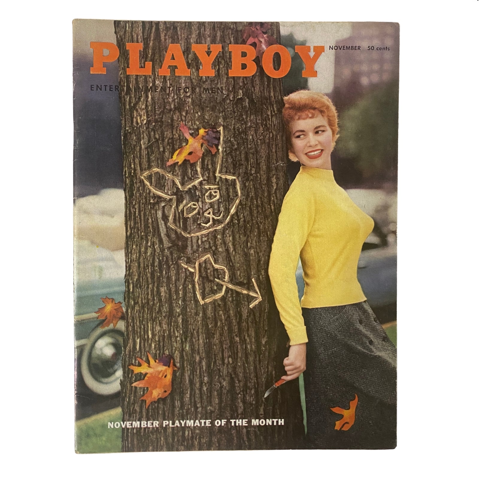 Playboy Magazine November 1955 featuring Barbara Cameron as Playmate of the Month, showcasing retro pin-up style with a yellow top and a charming smile next to a carved tree.