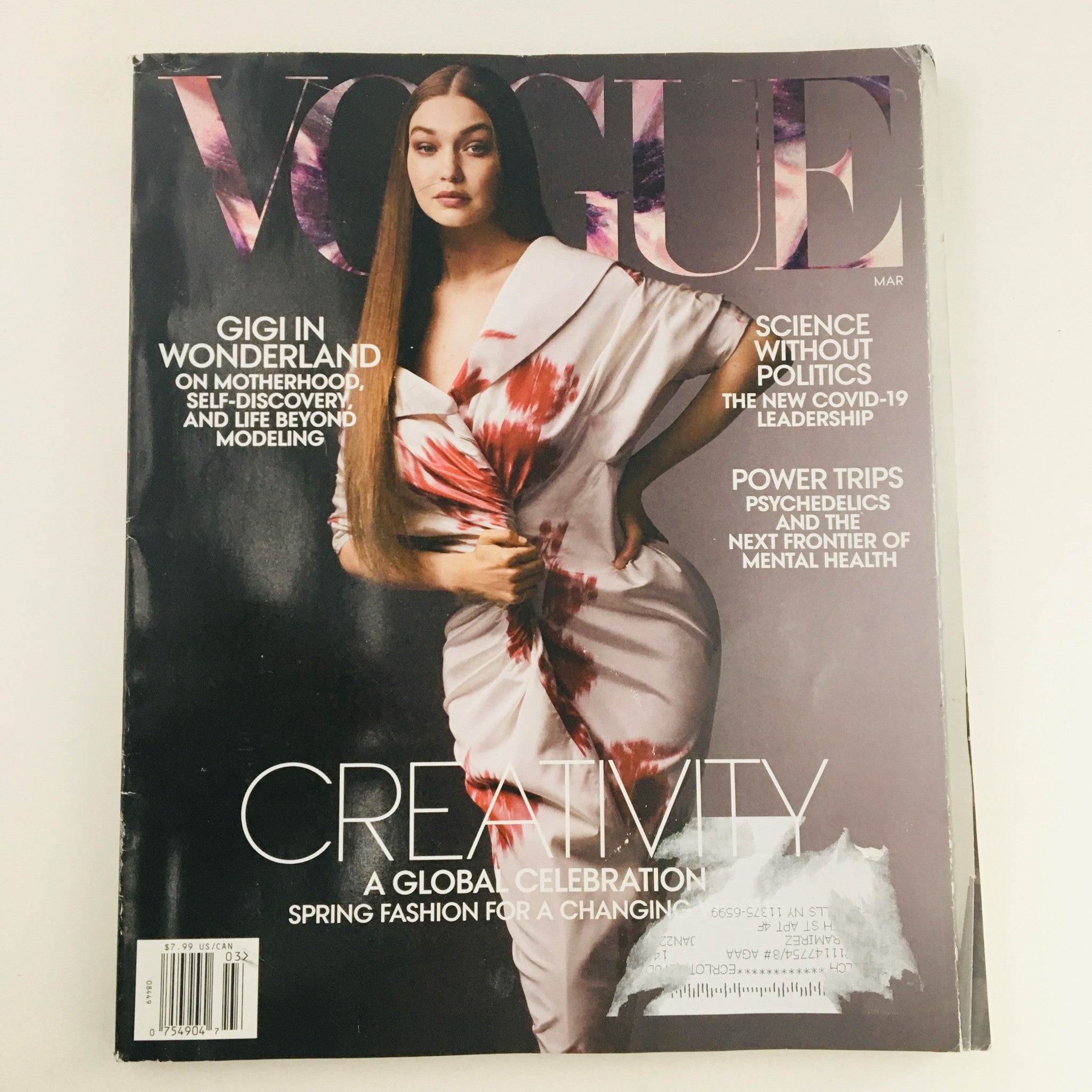 Cover of Vogue Magazine March 2021 featuring American model Gigi Hadid in a whimsical Wonderland theme, highlighting creativity and fashion.