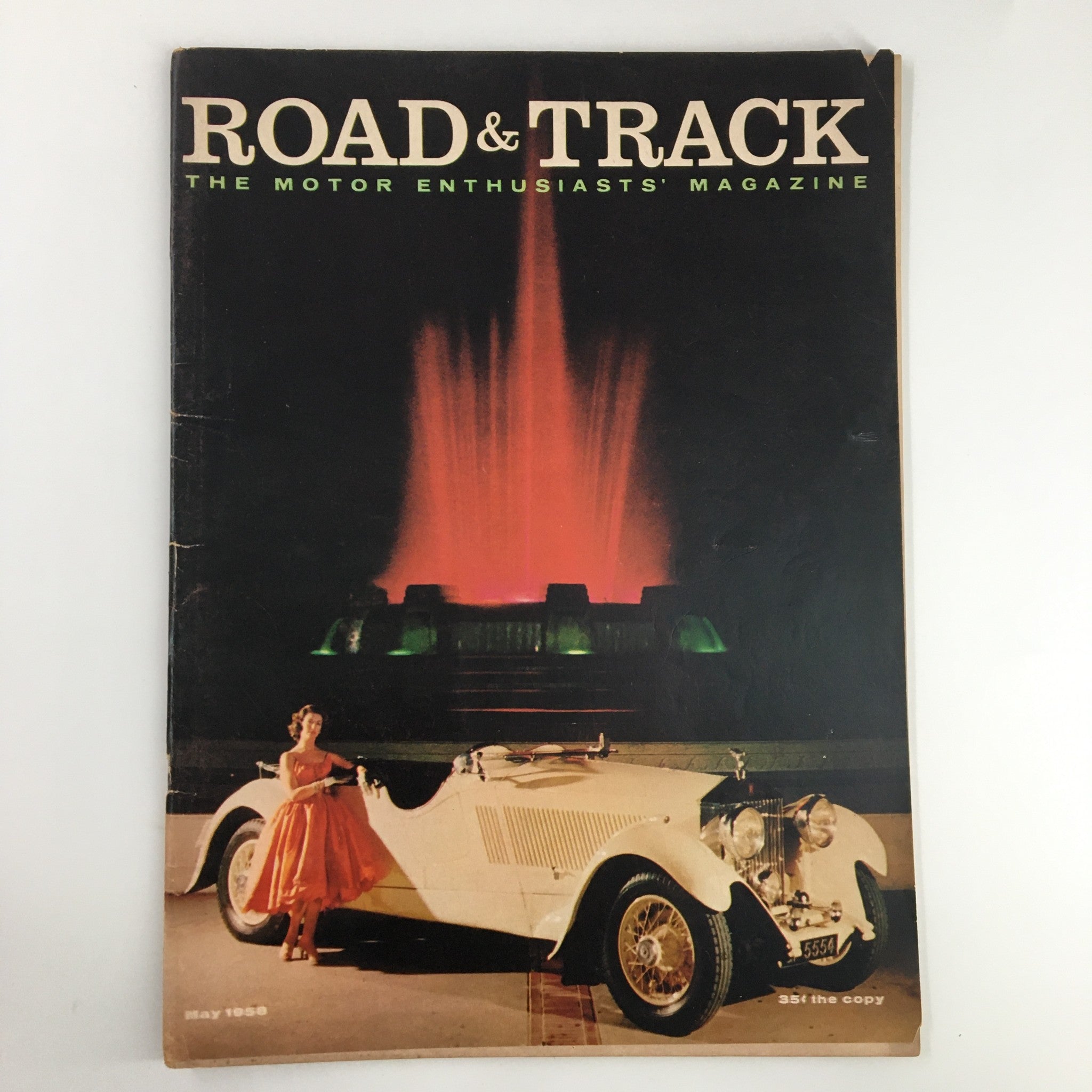 Cover of VTG Road & Track Magazine May 1958 featuring The Gigantic Rolls-Royce P-II with a woman in a pink dress beside a classic car and a fountain in the background.