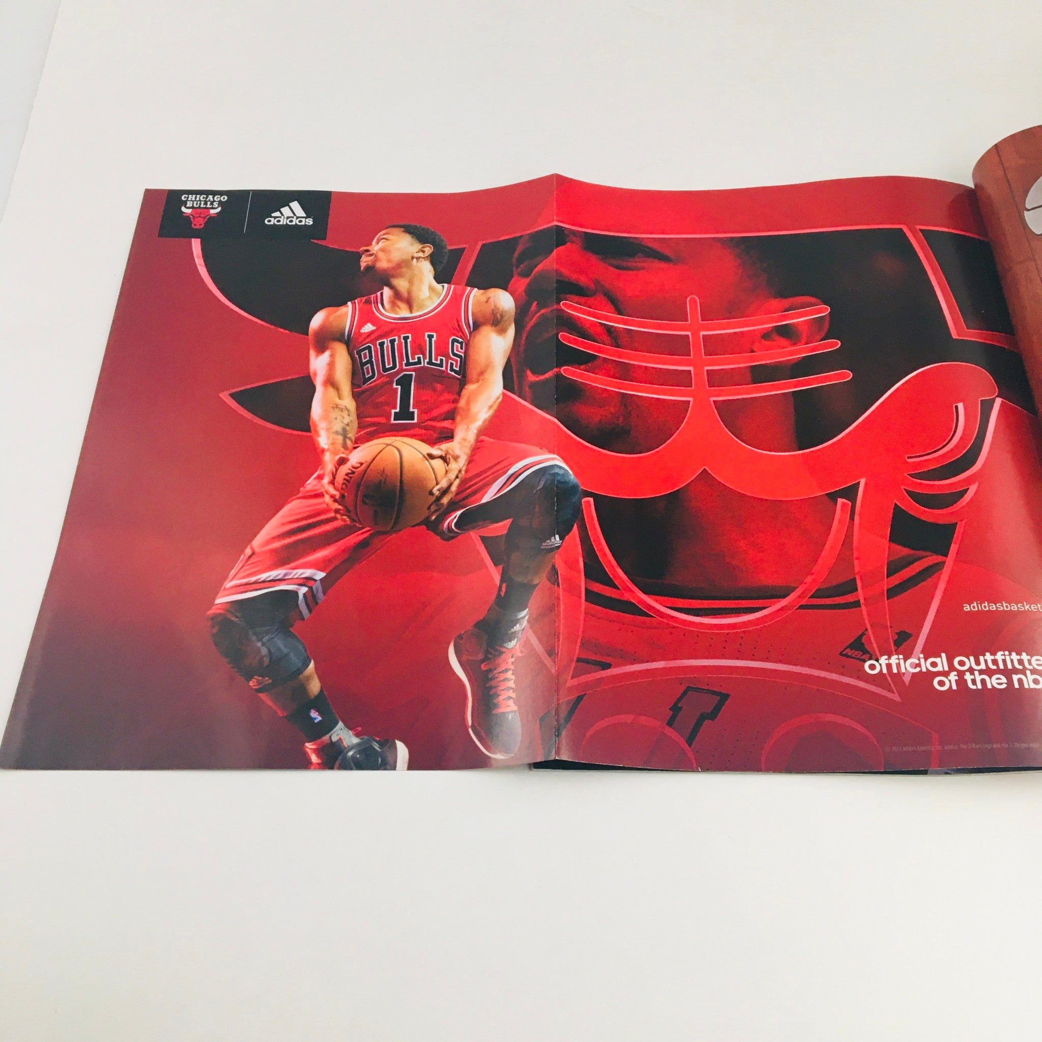 Inside spread of Slam Magazine February 2015 showcasing an advertisement featuring Derrick Rose in Chicago Bulls uniform against a bold red background.