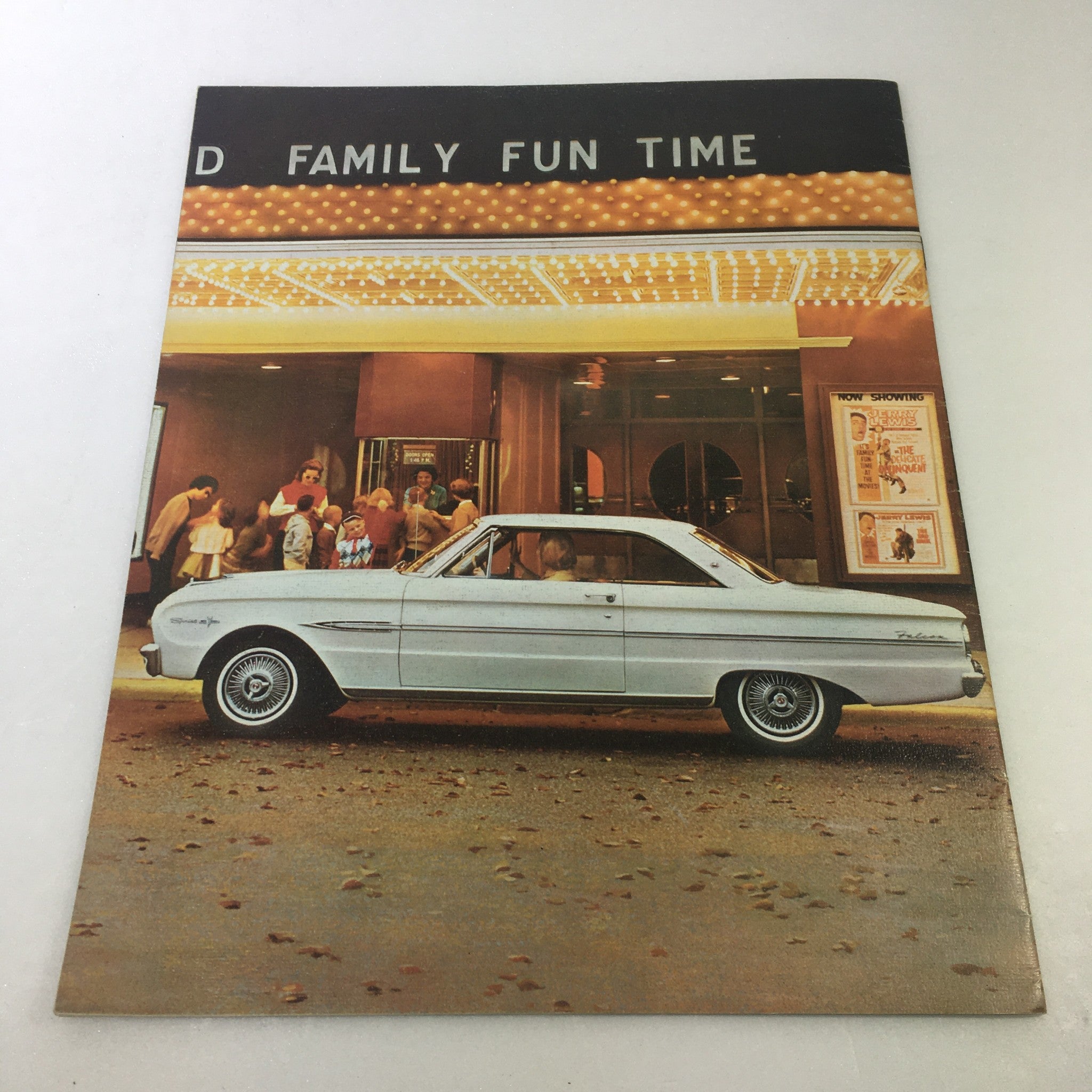 VTG 1963 Ford Falcon Futura Sports Convertible Car Auto Brochure Catalog displayed against a backdrop of a theater, showcasing the classic car next to people enjoying family fun time.