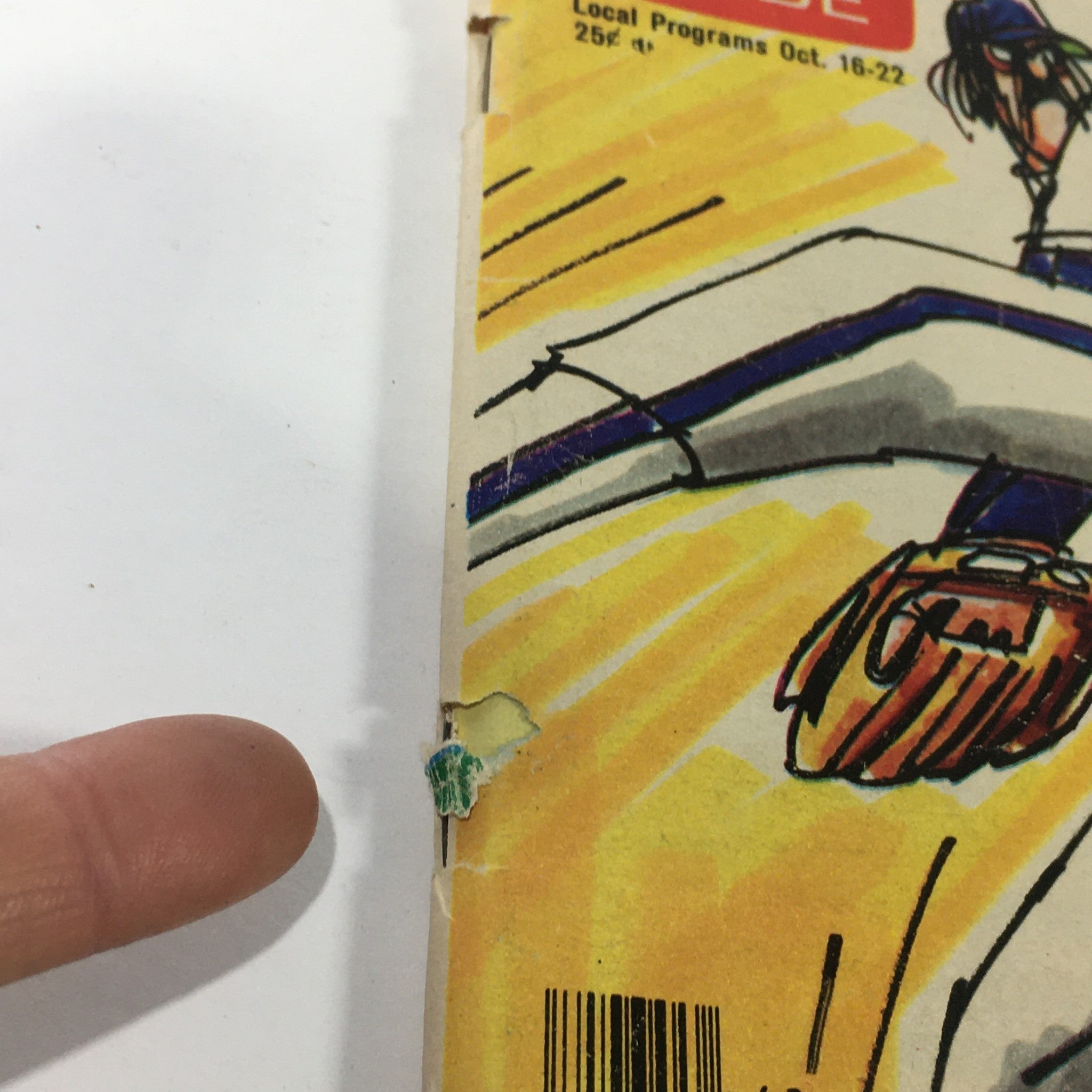 Close-up view of the spine of the Vintage TV Guide magazine from October 16-22, 1976, showing wear and tear, including marks and rips, along with the title 'World Series Jitters'.