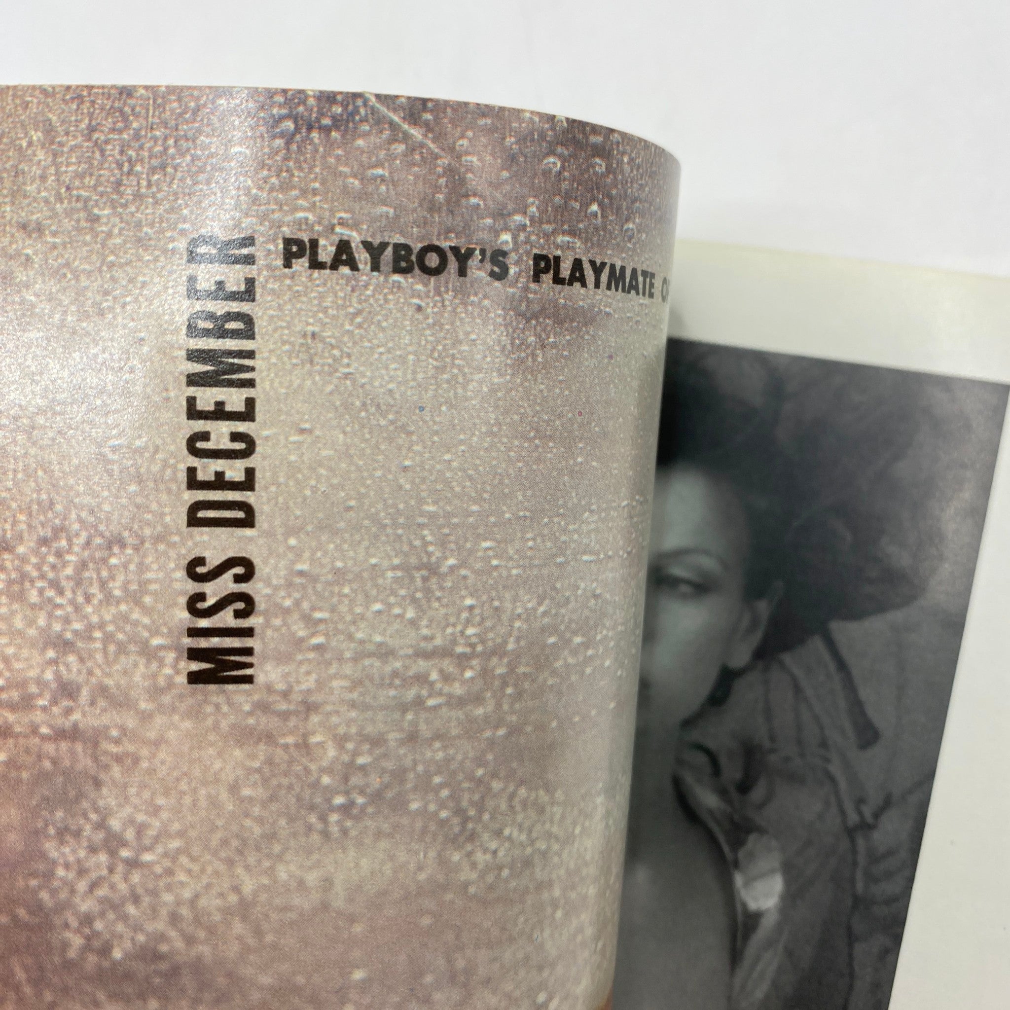 Inside page of Playboy Magazine December 1975, featuring a vintage advertisement for the centerfold Miss December, showcasing playful visuals and print aesthetics.
