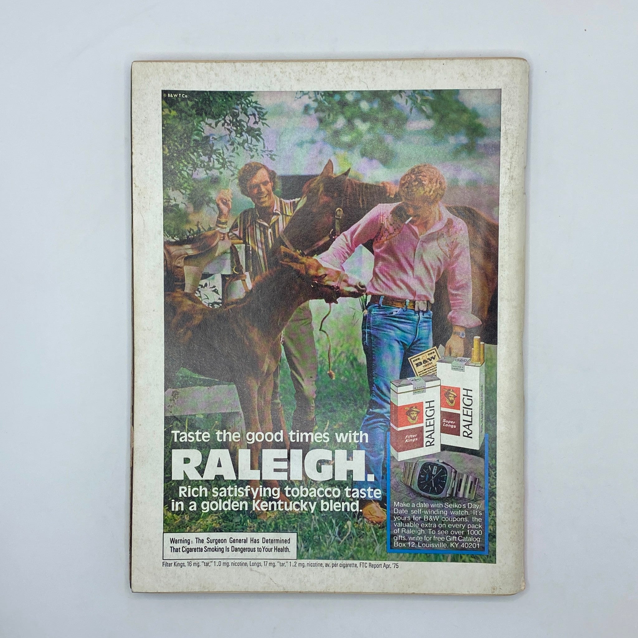 Back cover of Playboy Magazine December 1975, displaying an advertisement for Raleigh cigarettes, capturing mid-1970s pop culture and vintage marketing style.