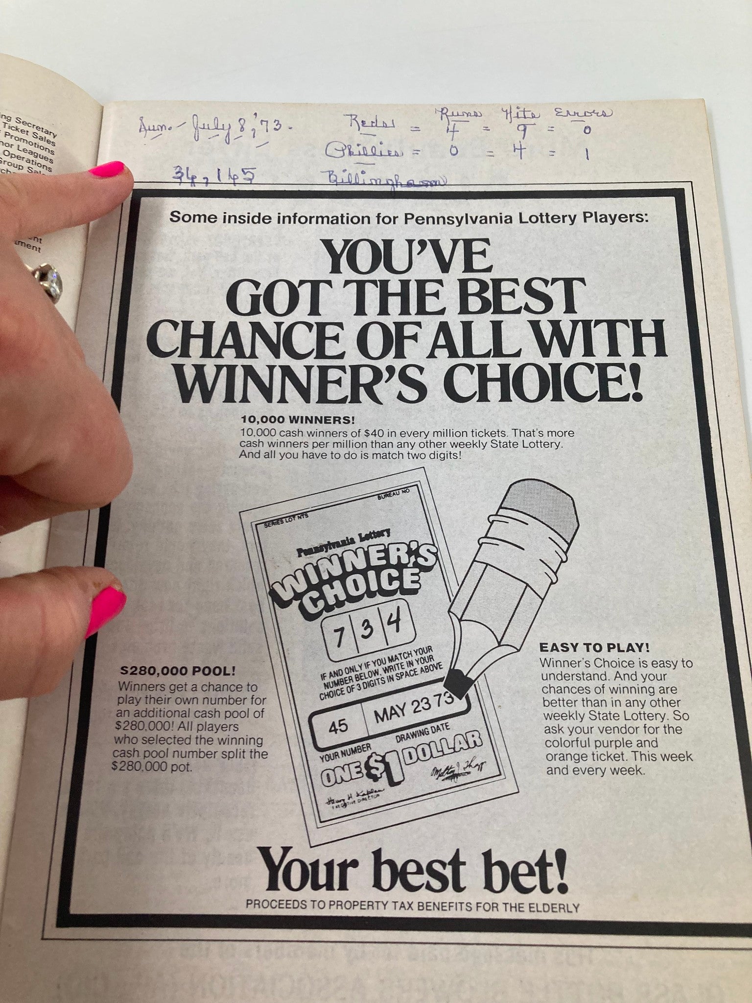 Inside page of the 1973 MLB Philadelphia Phillies Magazine showing a Pennsylvania Lottery advertisement with handwritten game details.