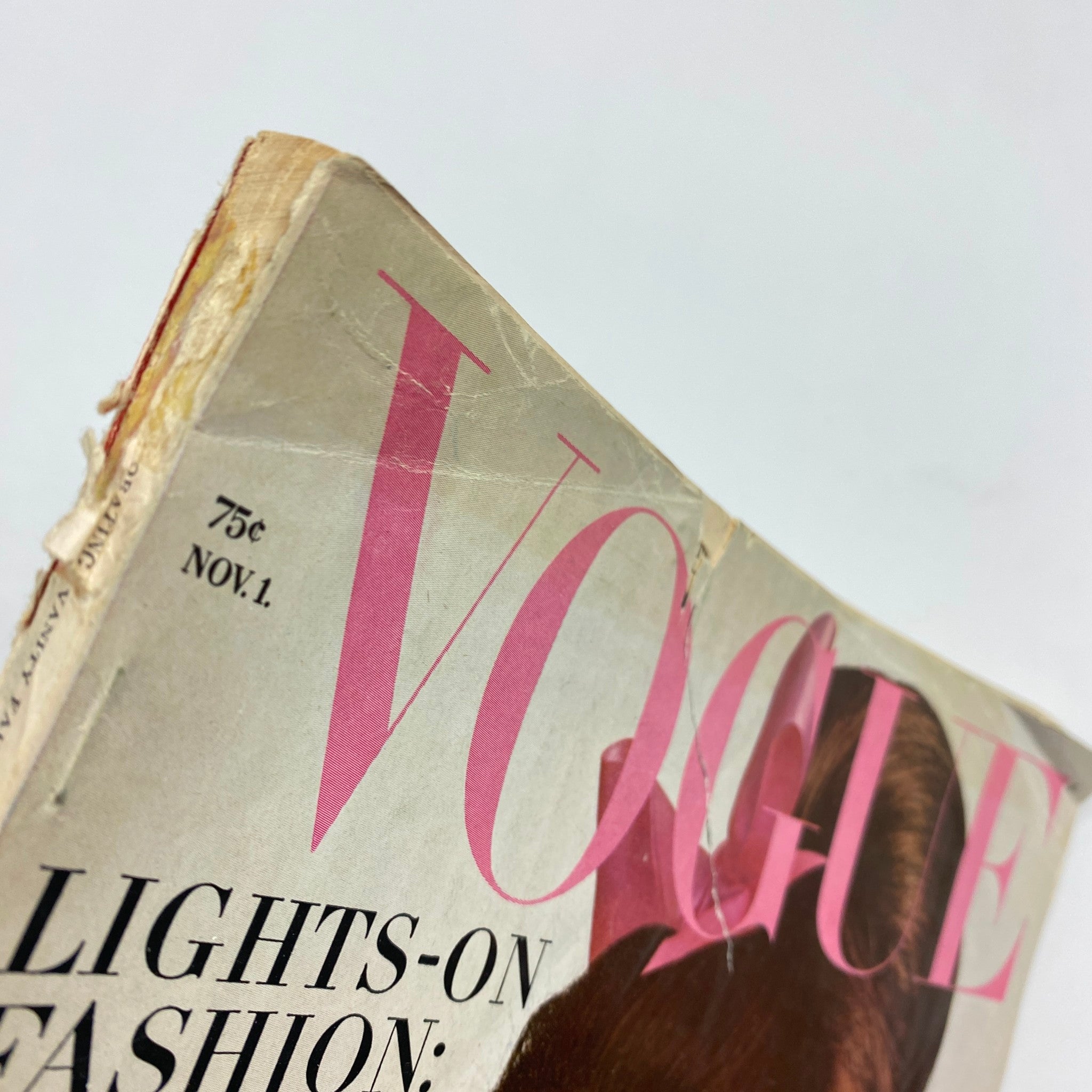 Close-up of the vintage Vogue Magazine from November 1, 1965 featuring Brigitte Bauer, highlighting the magazine's title with some signs of weathering.