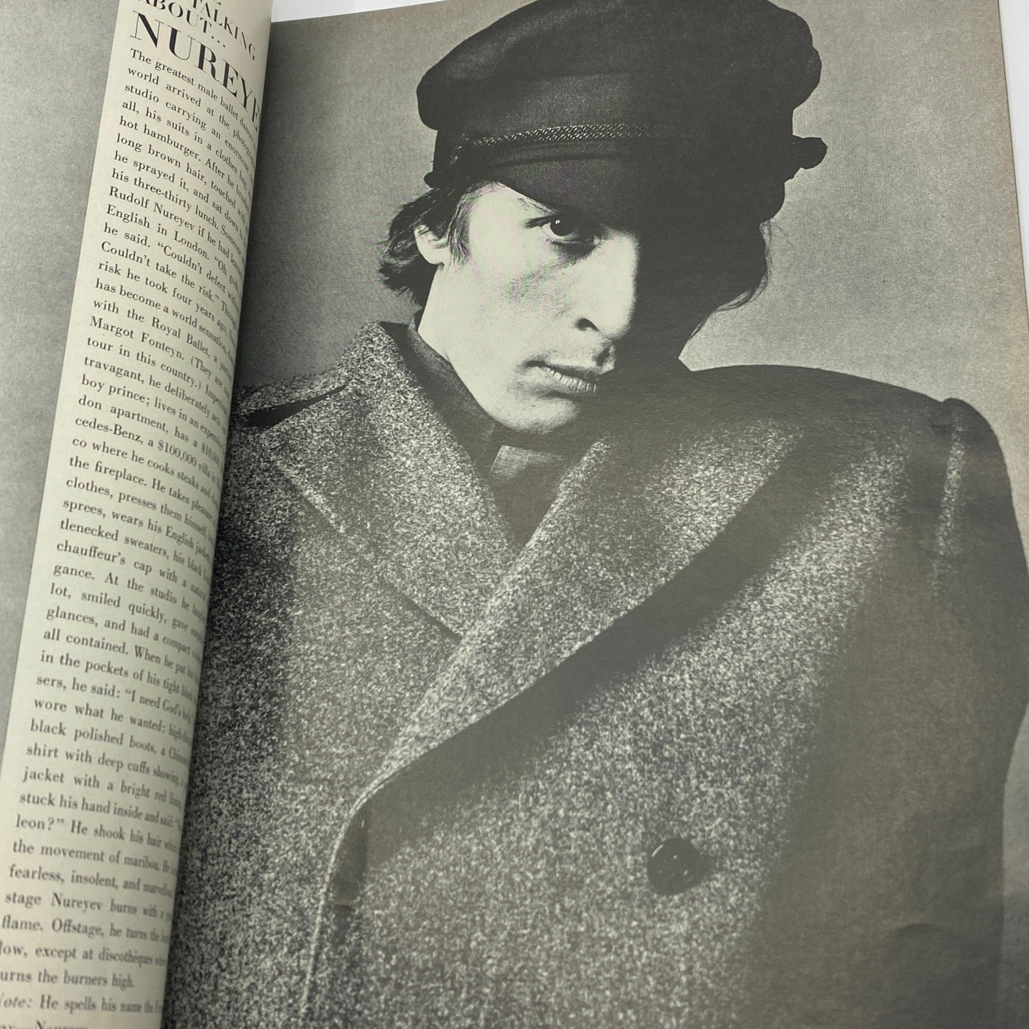 Vintage Vogue Magazine July 1965 featuring a striking black and white photograph of a male model in a stylish overcoat and cap, capturing the essence of 1960s fashion. Photographed by Irving Penn.