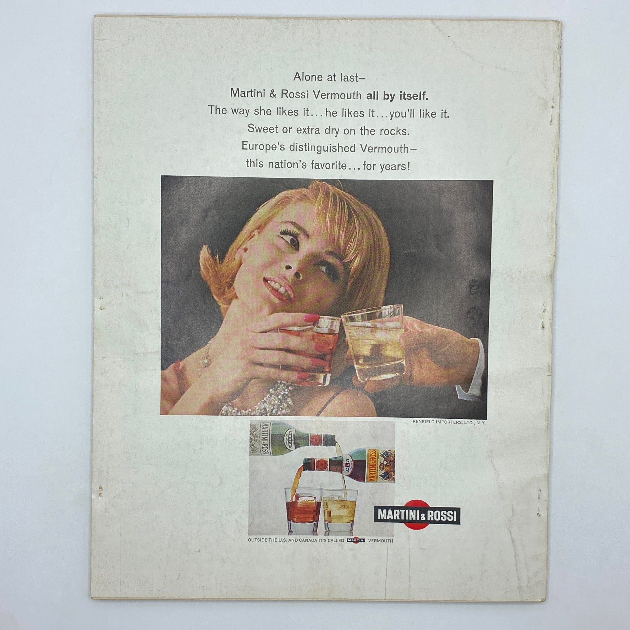 The back cover of Vintage Vogue Magazine July 1965, showcasing an advertisement for Martini & Rossi Vermouth, featuring a glamorous woman toasting with drinks, symbolizing the chic lifestyle of the 1960s.