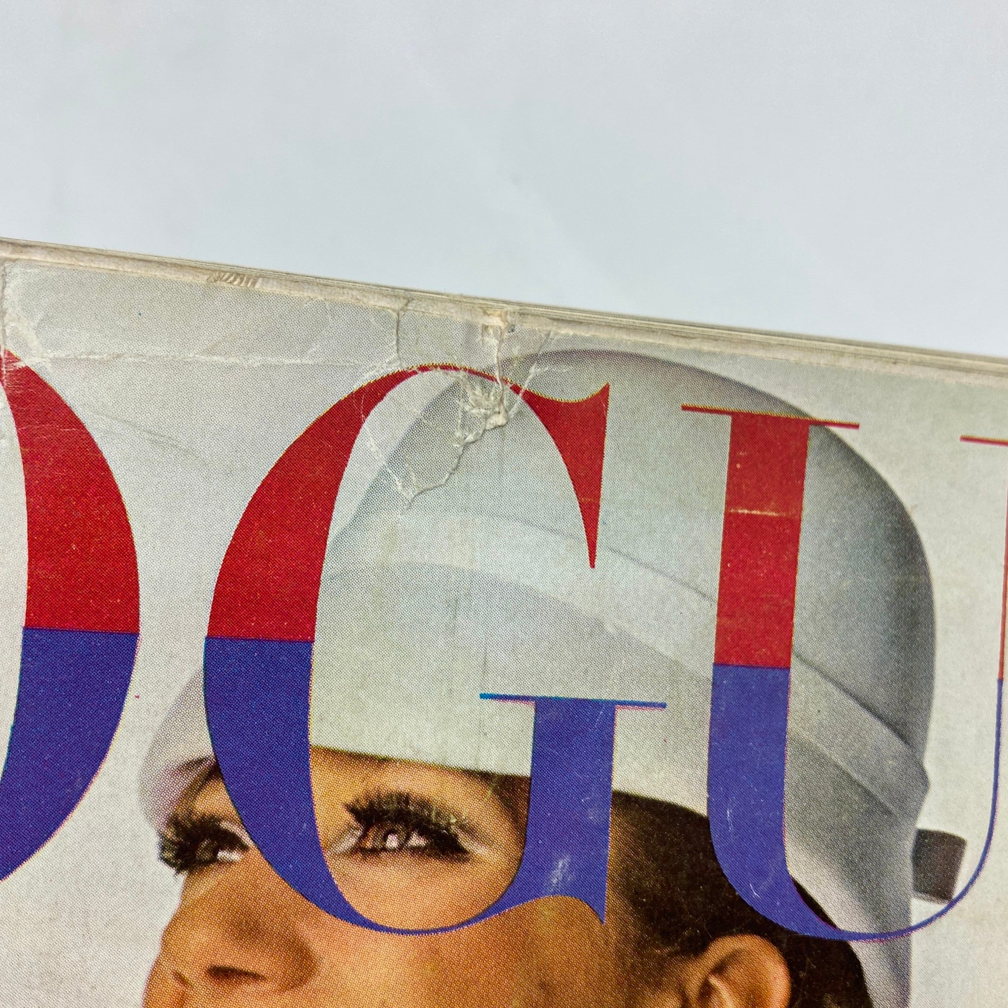 Close-up of the cover of VTG Vogue Magazine February 1 1966 featuring the iconic letters of 'VOGUE' and a glimpse of Marisa Berenson's face.