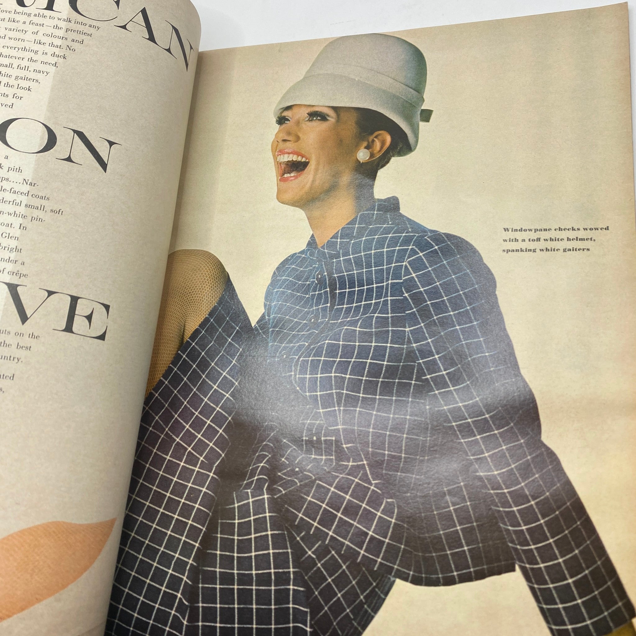 Candid fashion shot in VTG Vogue Magazine February 1 1966 displaying a model in a striking outfit and hat, exemplifying 1960s style.