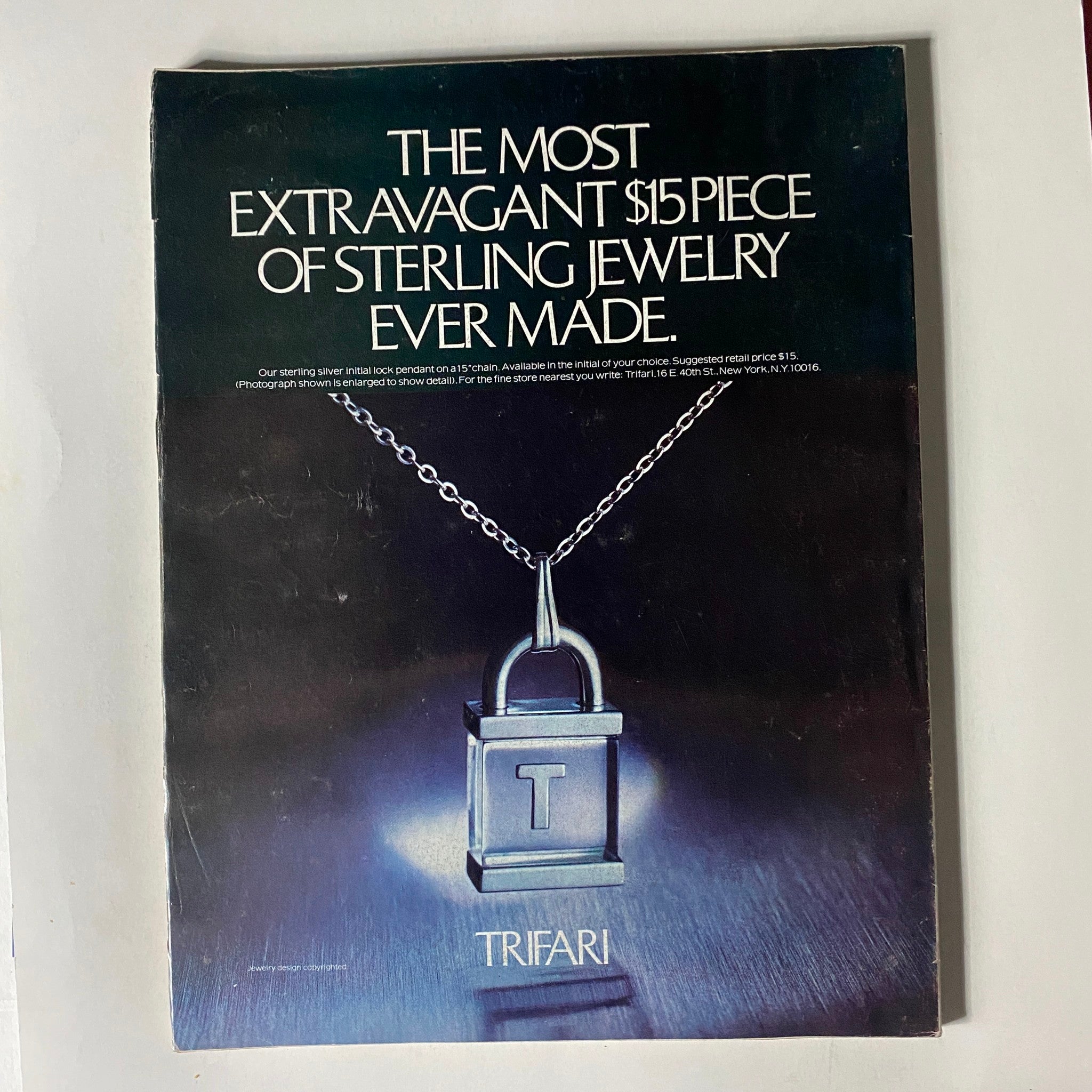 Back cover of VTG Vogue Magazine March 1976 featuring an advertisement for Trifari jewelry, showcasing a sterling silver pendant with a lock design.