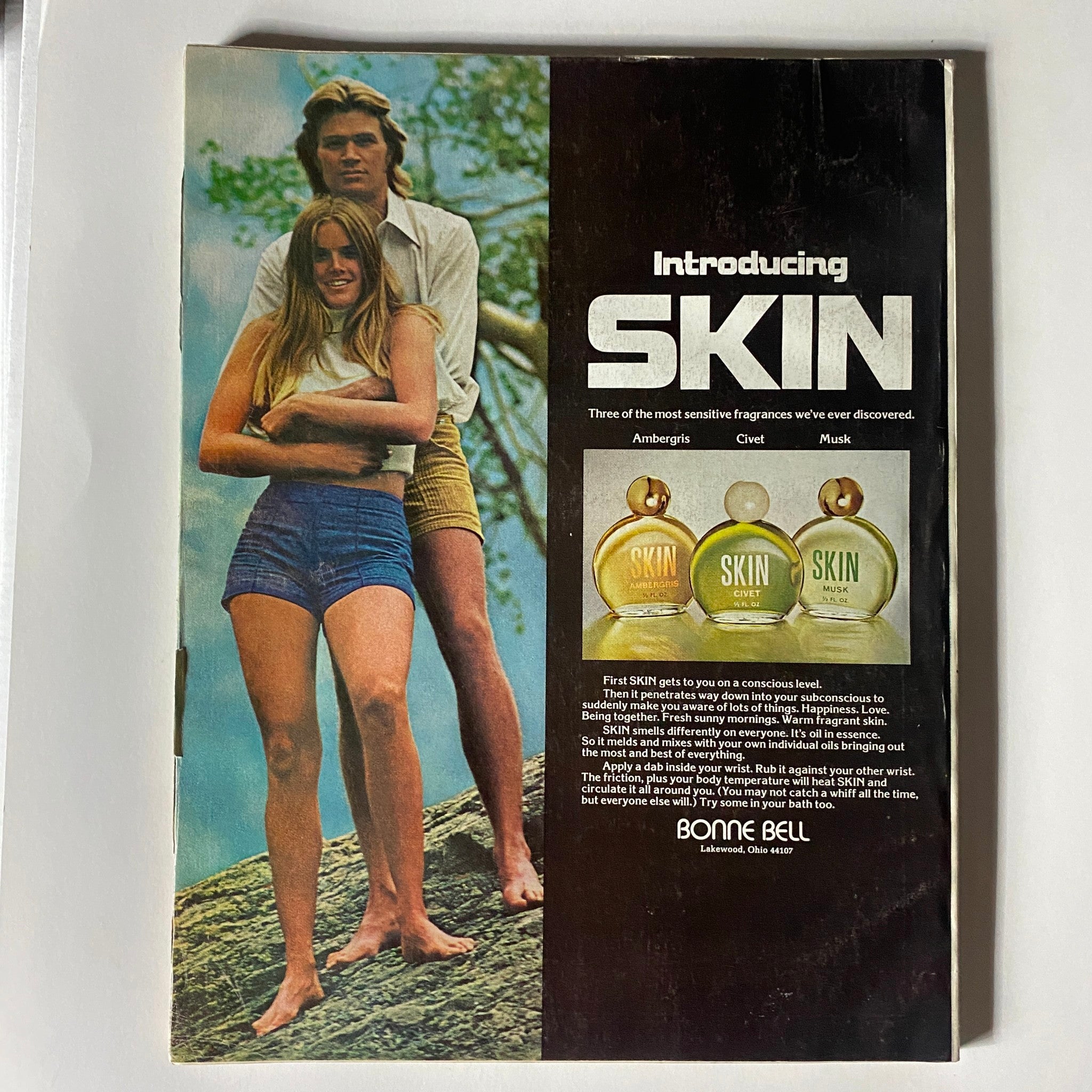 Back cover of VTG Vogue Magazine November 1973 featuring Cybill Shepherd by Helmut Newton, showcasing a model advertisement for 'Skin' fragrances with a vibrant nature background.