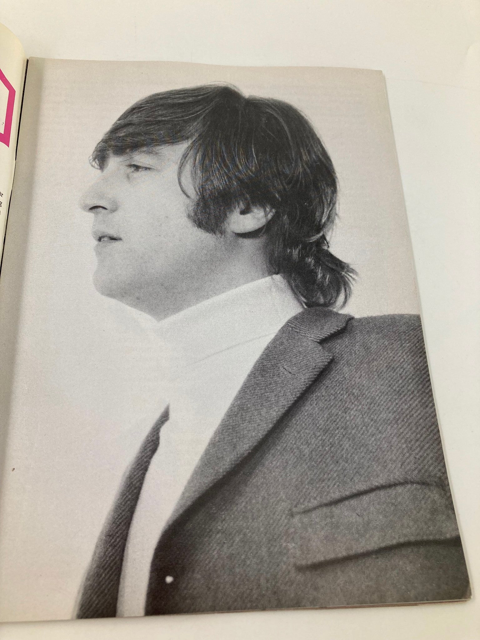 Black and white photograph featuring John Lennon from The Beatles as he appears in the Beatles Book Monthly Magazine February 1986 #118, showcasing his profile with a contemplative expression.