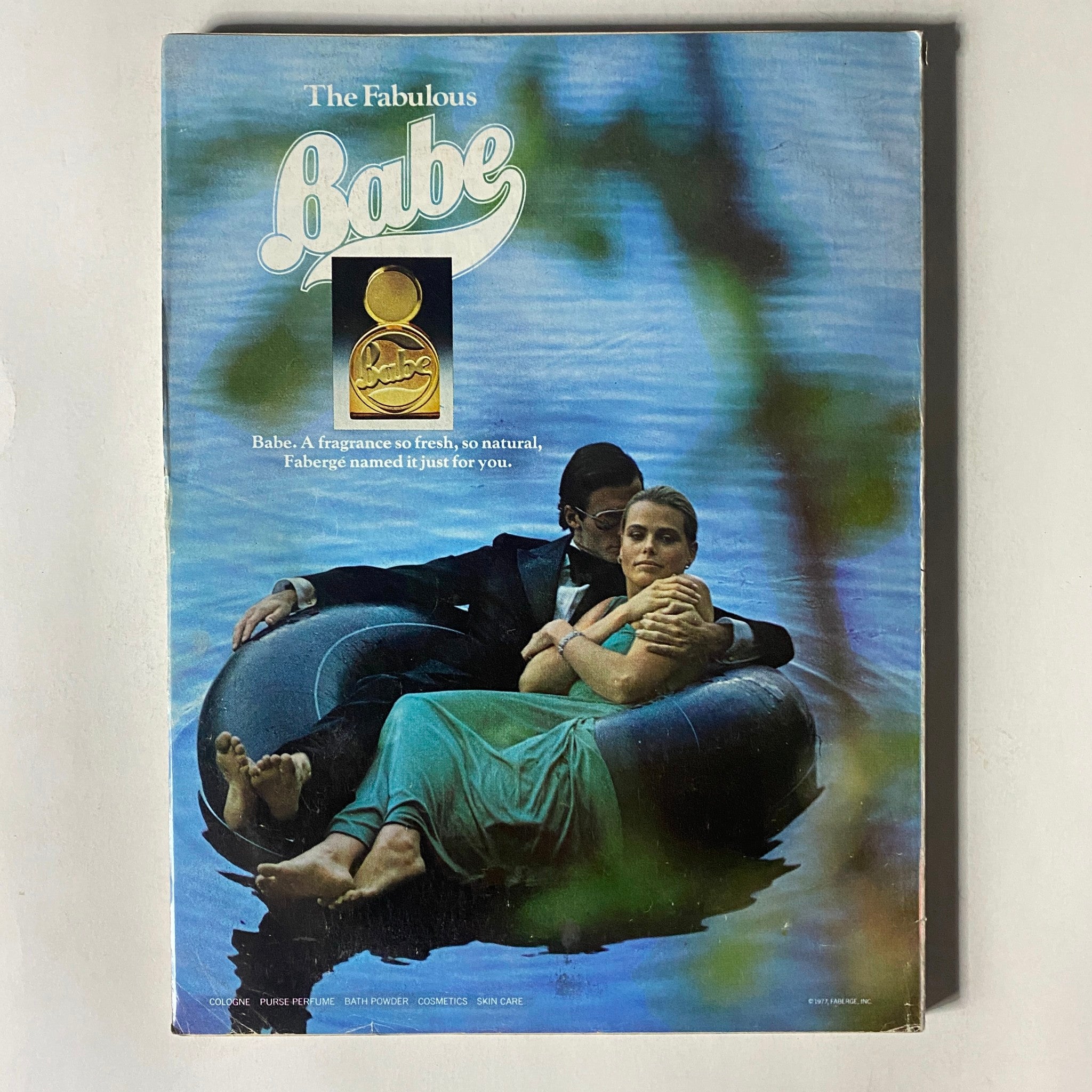 Vintage Vogue Magazine December 1977 cover showcasing an elegant couple on a serene lake, advertising Babe fragrance by Fabergé, encapsulating the romantic essence of vintage fashion.