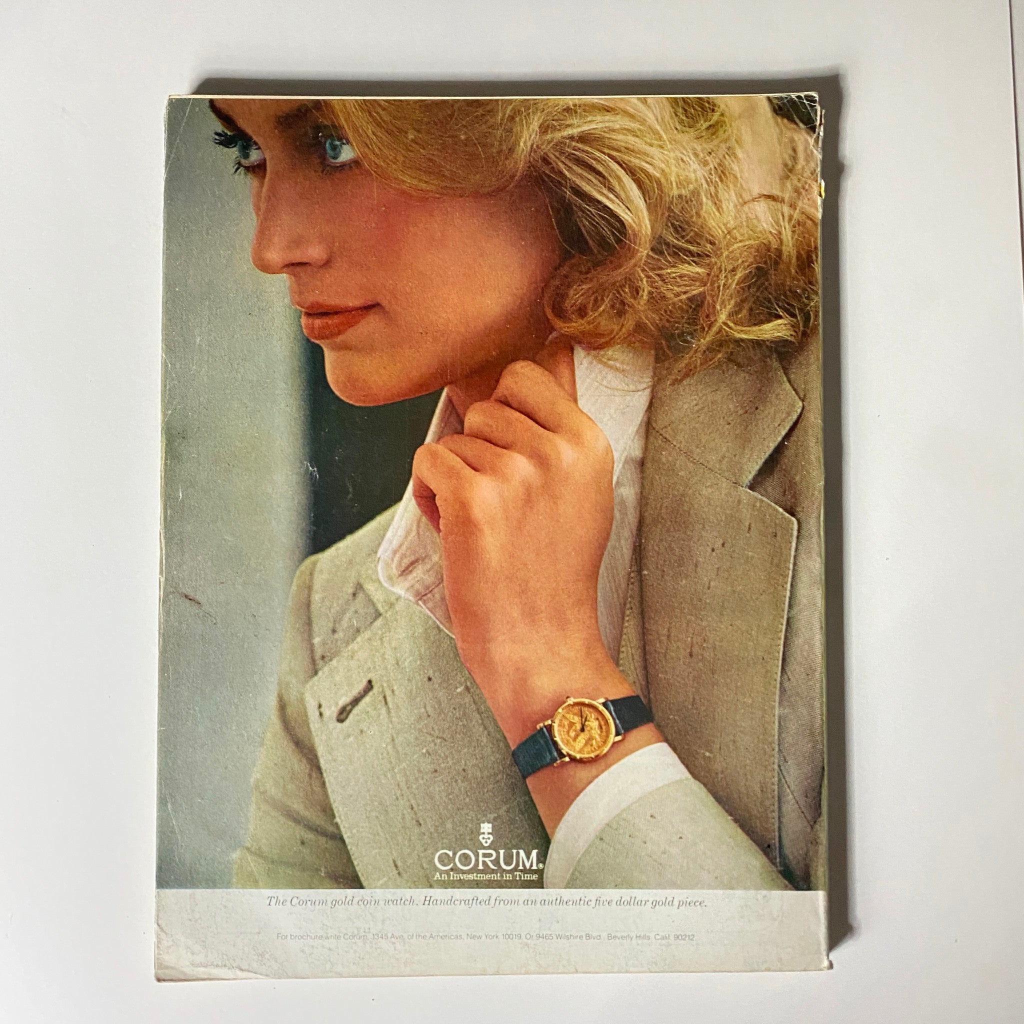 VTG Vogue Magazine August 1978 advertisement highlighting a stylish woman wearing a Corum gold coin watch, showcasing vintage jewelry and fashion.