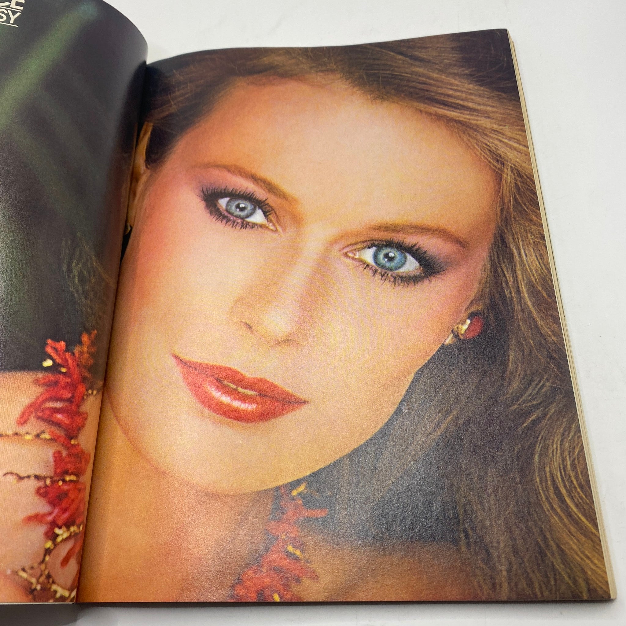 Close-up beauty shot of a model with captivating blue eyes and glamorous makeup from VTG Vogue Magazine March 1981, showcasing the era's beauty standards.