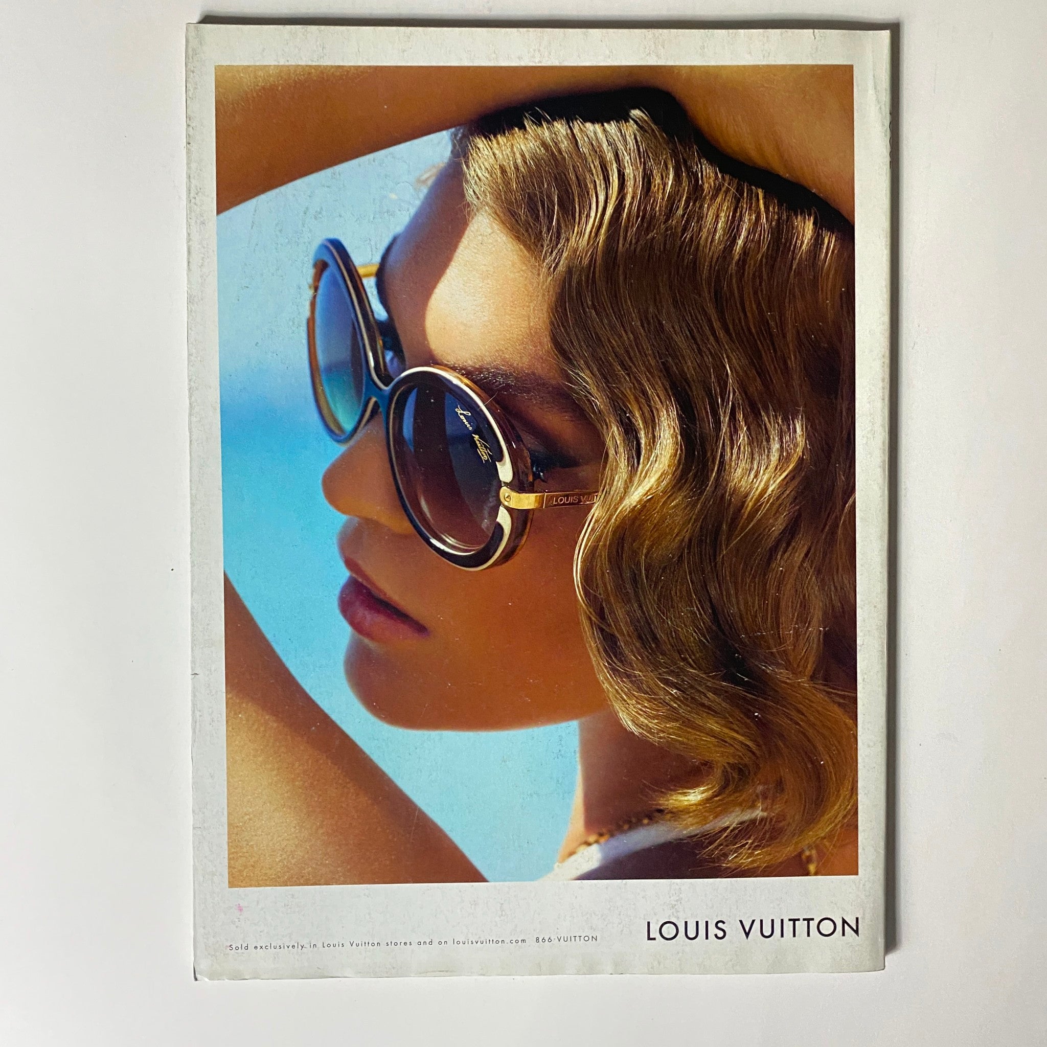 Louis Vuitton advertisement from Vogue Magazine July 2012 featuring a stylish model wearing sunglasses against a bright backdrop.