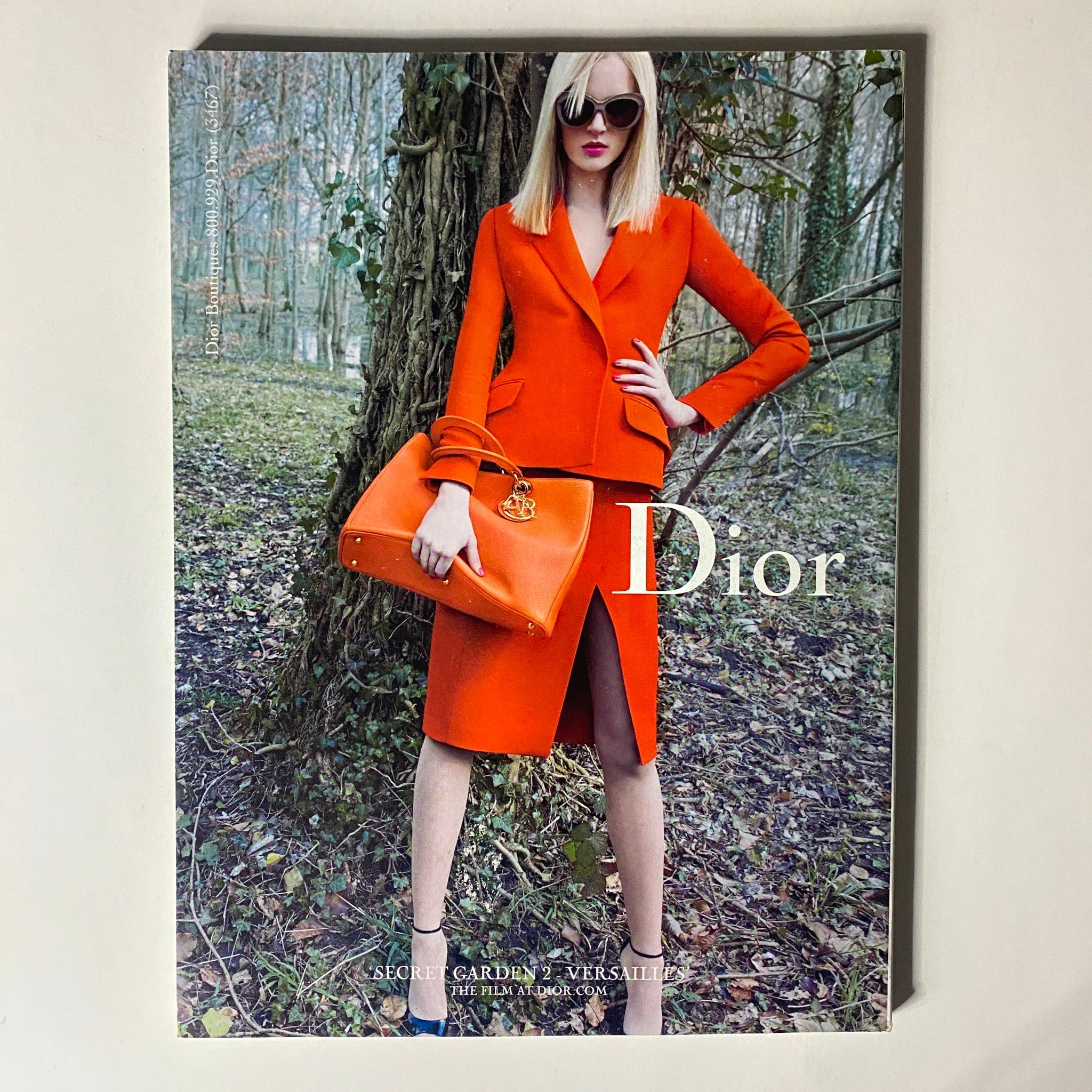 Cover of Vogue Magazine August 2013 featuring a model in a striking orange Dior outfit amidst a forest backdrop.