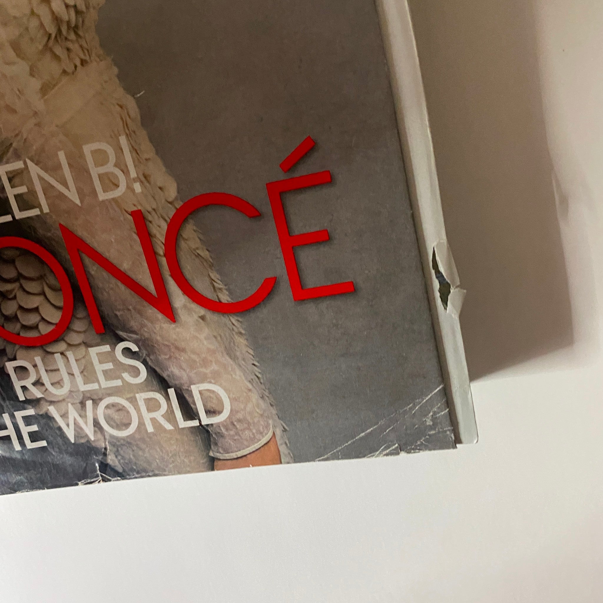 Close-up of the cover of Vogue Magazine March 2013 featuring Beyonce, showcasing the title 'Queen B: Beyonce Rules the World' with visible wear.