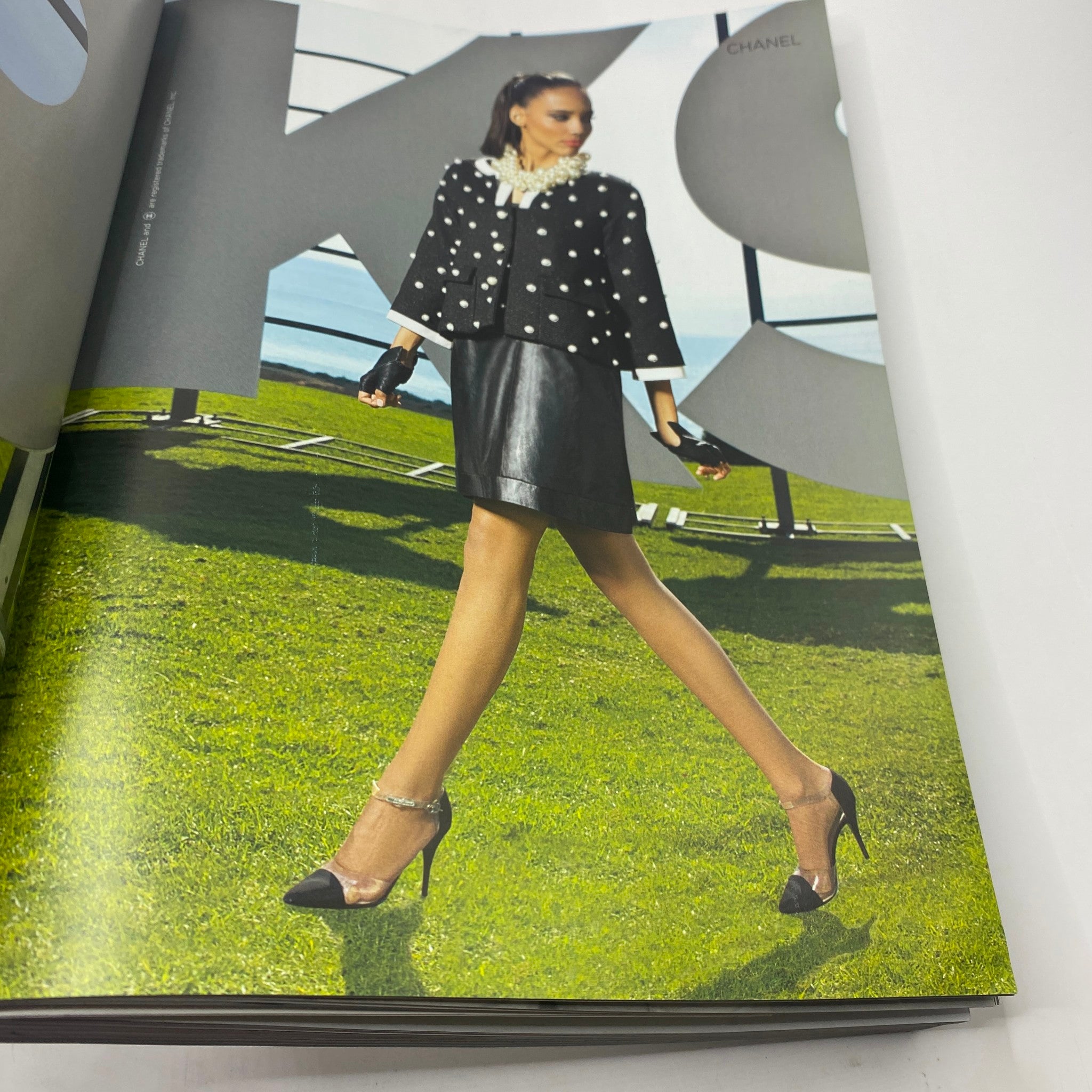 Vogue Magazine March 2013 Beyonce Power Issue - A high-fashion image of a model in a stylish Chanel outfit, showcasing confidence and contemporary elegance on a vibrant green backdrop.