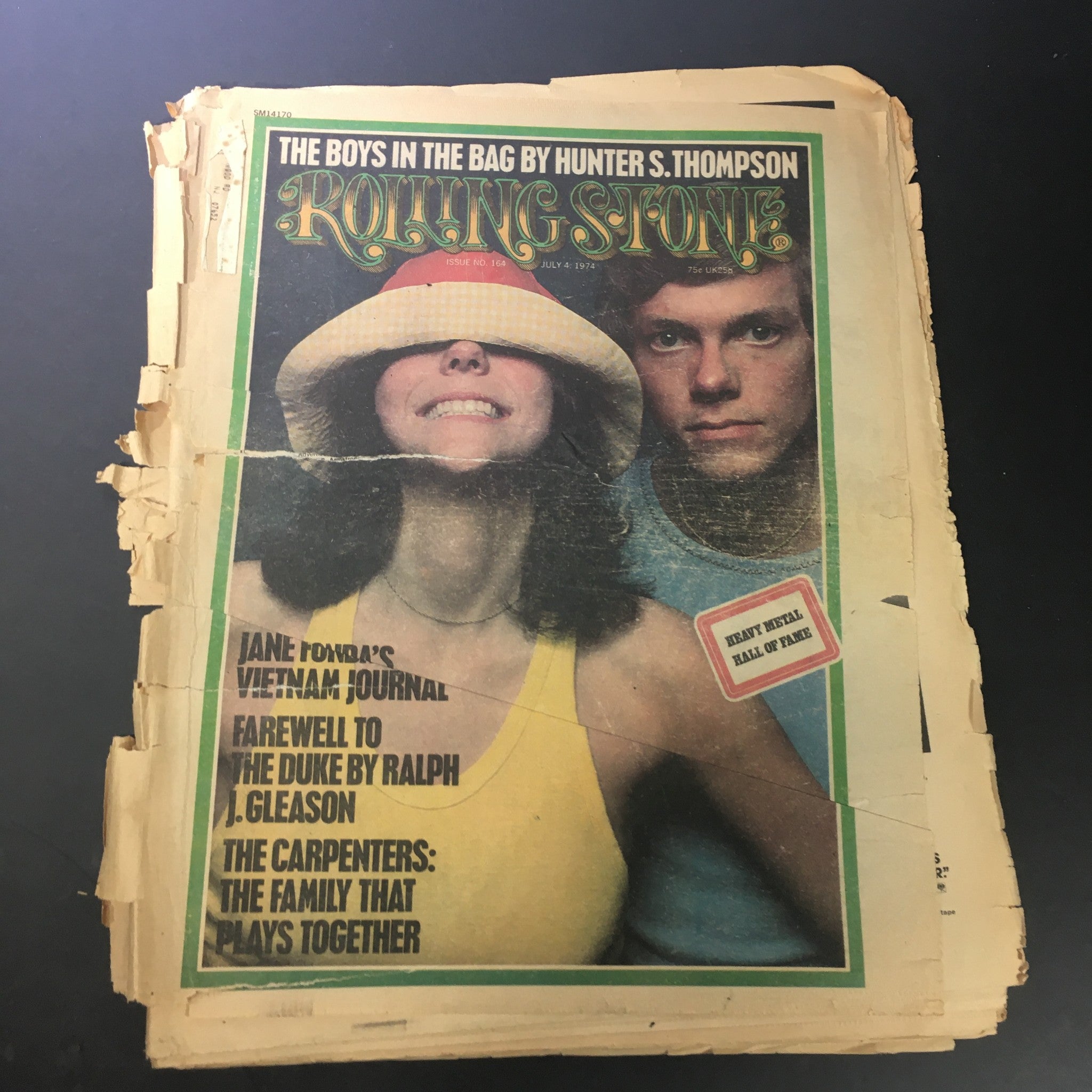 Vintage Rolling Stone magazine from July 4, 1974, featuring Jane Fonda on the cover, showcasing signs of wear with edge rips, adding character to this collectible magazine.