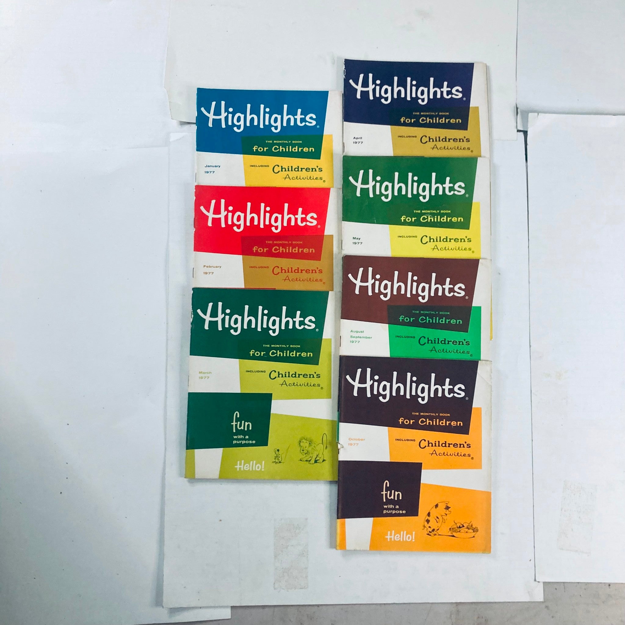 Lot of 7 1977 Vintage Highlights for Children Magazine, showcasing the covers of the magazines arranged in a stack with colorful designs representing different months.