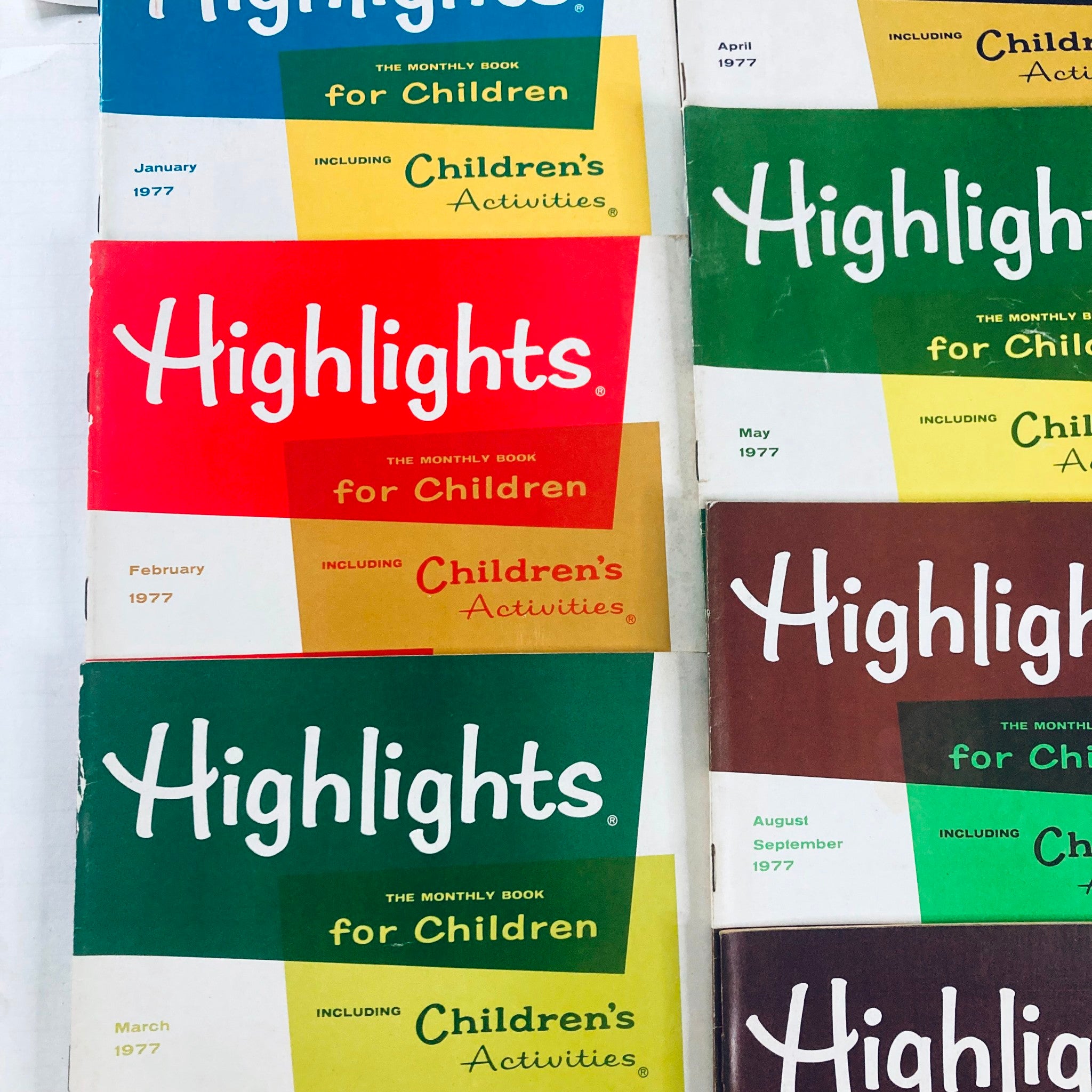 Lot of 7 1977 Vintage Highlights for Children Magazine, featuring close-up views of the magazine covers with vibrant colors and publication dates from January to May 1977.