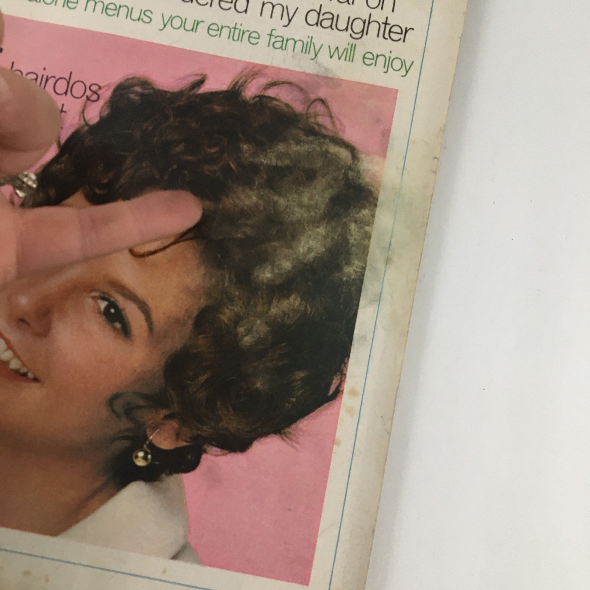 Close-up of Good Housekeeping Magazine April 1970 cover, highlighting a smiling woman with curly hair and the article title about 24 new hairdos and makeup ideas.