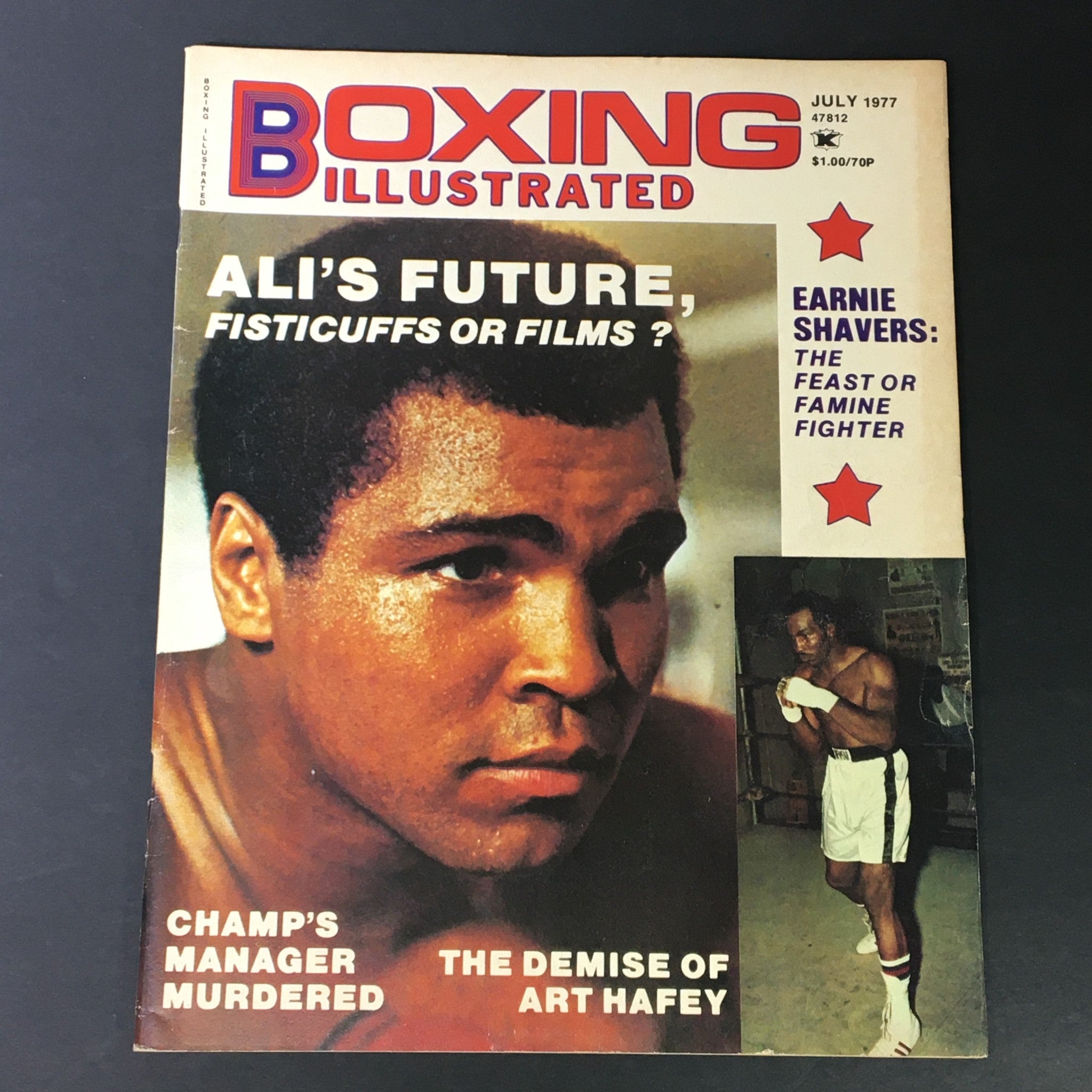 Cover of VTG Boxing Illustrated Magazine from July 1977 featuring Muhammad Ali, focused on his future in boxing, with the headline 'ALIS FUTURE, FISTICUFFS OR FILMS?'. The cover highlights significant boxing events of the era, including the murder of a champion's manager and the demise of Art Hafey.