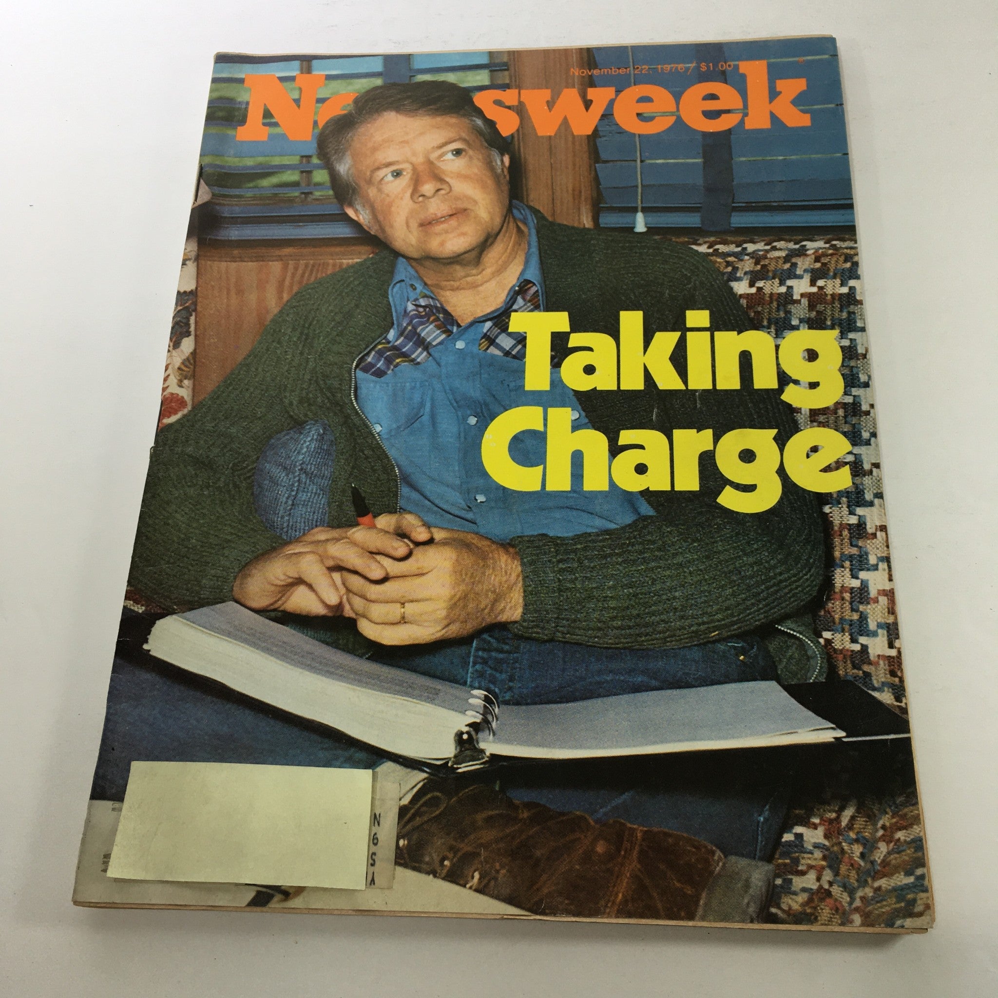 Cover of Newsweek Magazine from November 22, 1976, featuring the title 'Taking Charge: Jimmy Carter,' depicting Jimmy Carter in casual attire, engaged in thoughtful contemplation with a notebook in front of him.