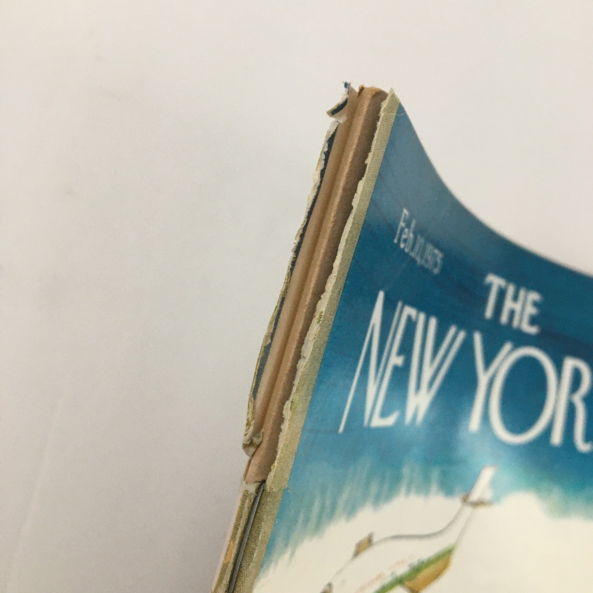 Side view of The New Yorker Magazine February 10, 1975, displaying some minor wear and tear, including frayed edges, indicative of its vintage status.